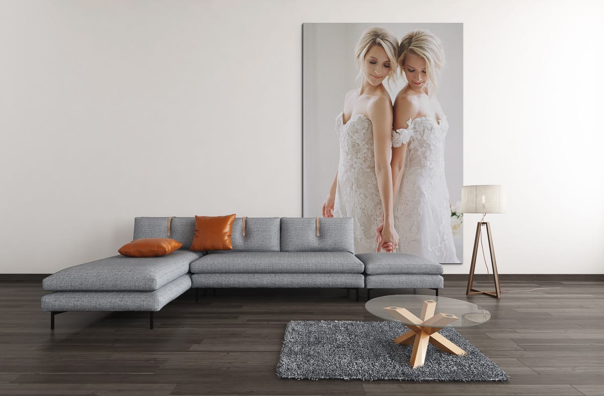 same sex bridal portraits displayed on a huge fine art metal print in a living room