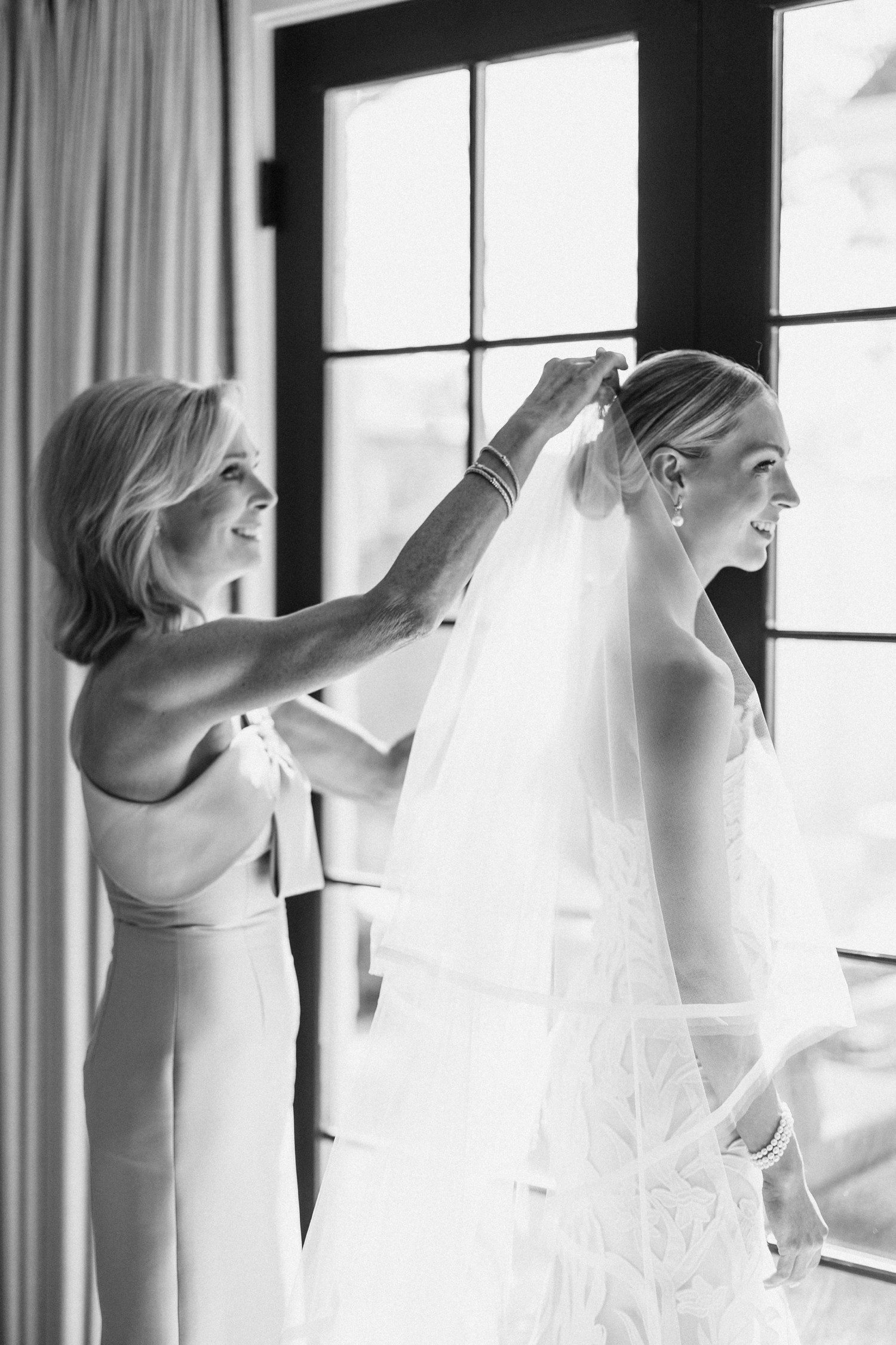 Mom putting veil in bride's hair