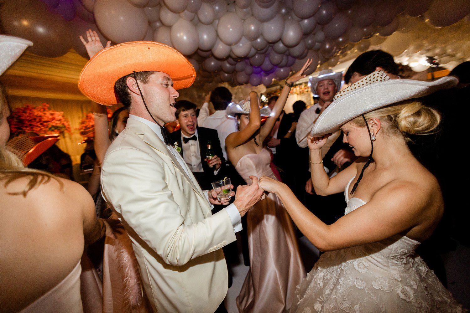 Bride and Groom dancing with cowboy hats at reception