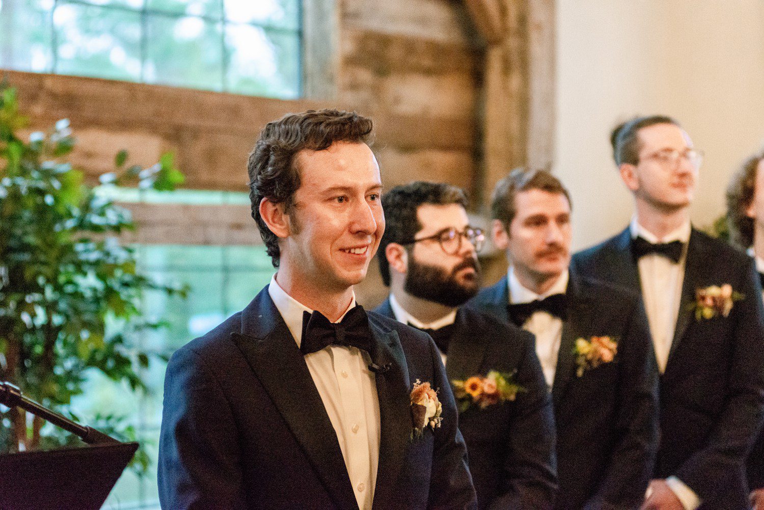 Groom watching bride walk down aisle 