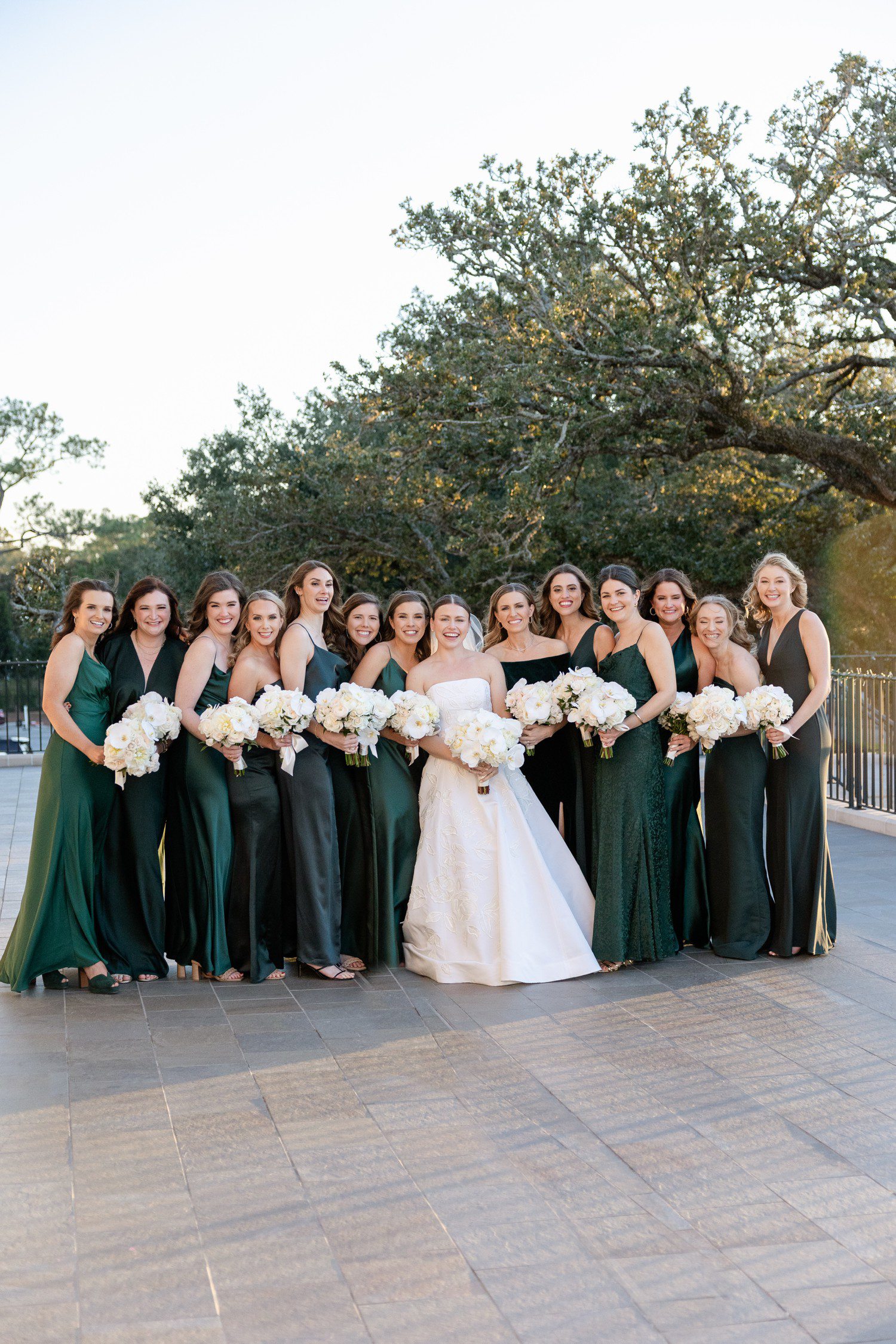 Bridesmaids in green dresses with white bouquets at Houston Country Club 