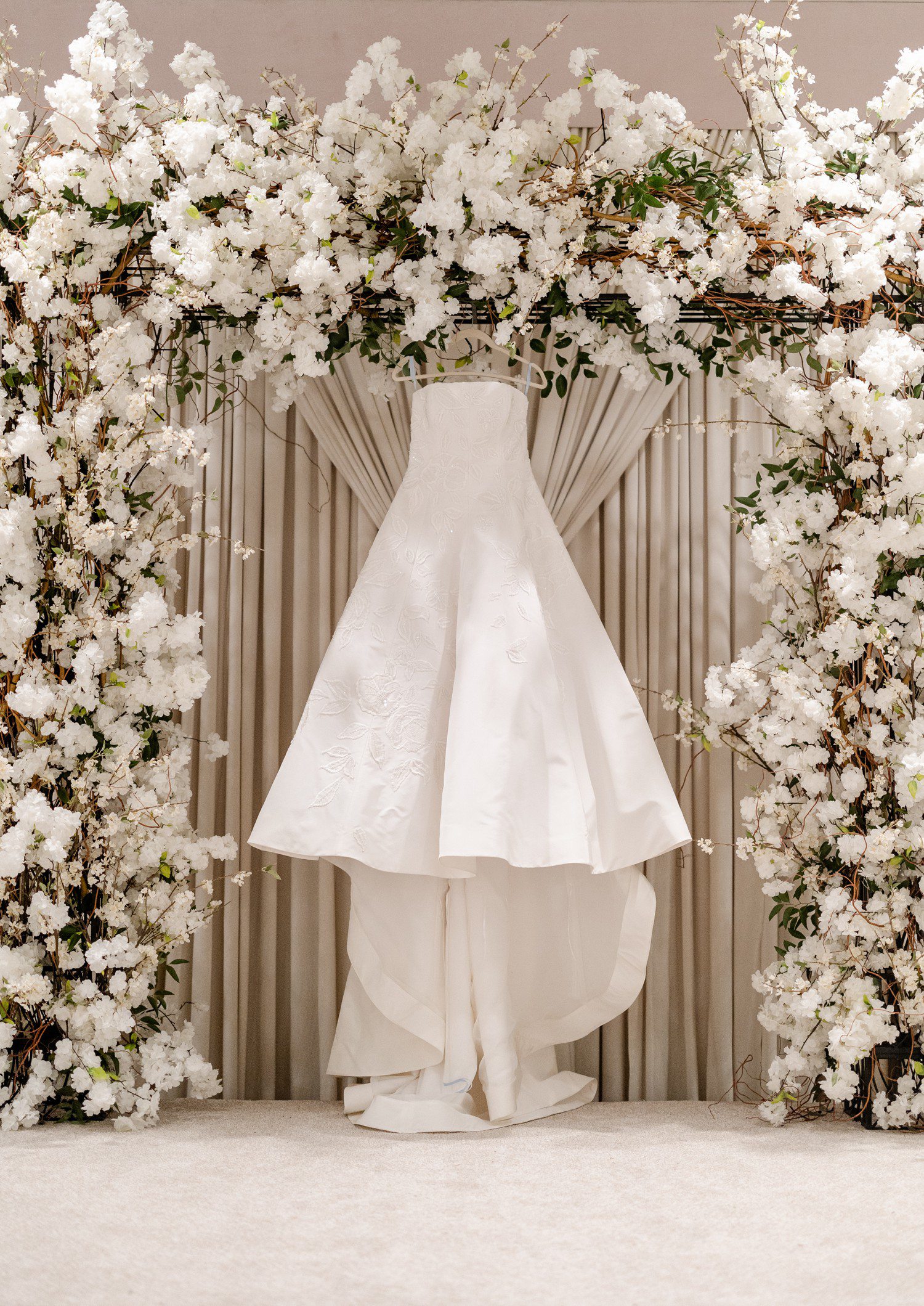 Wedding Dress Hanging under cherry blossom arch