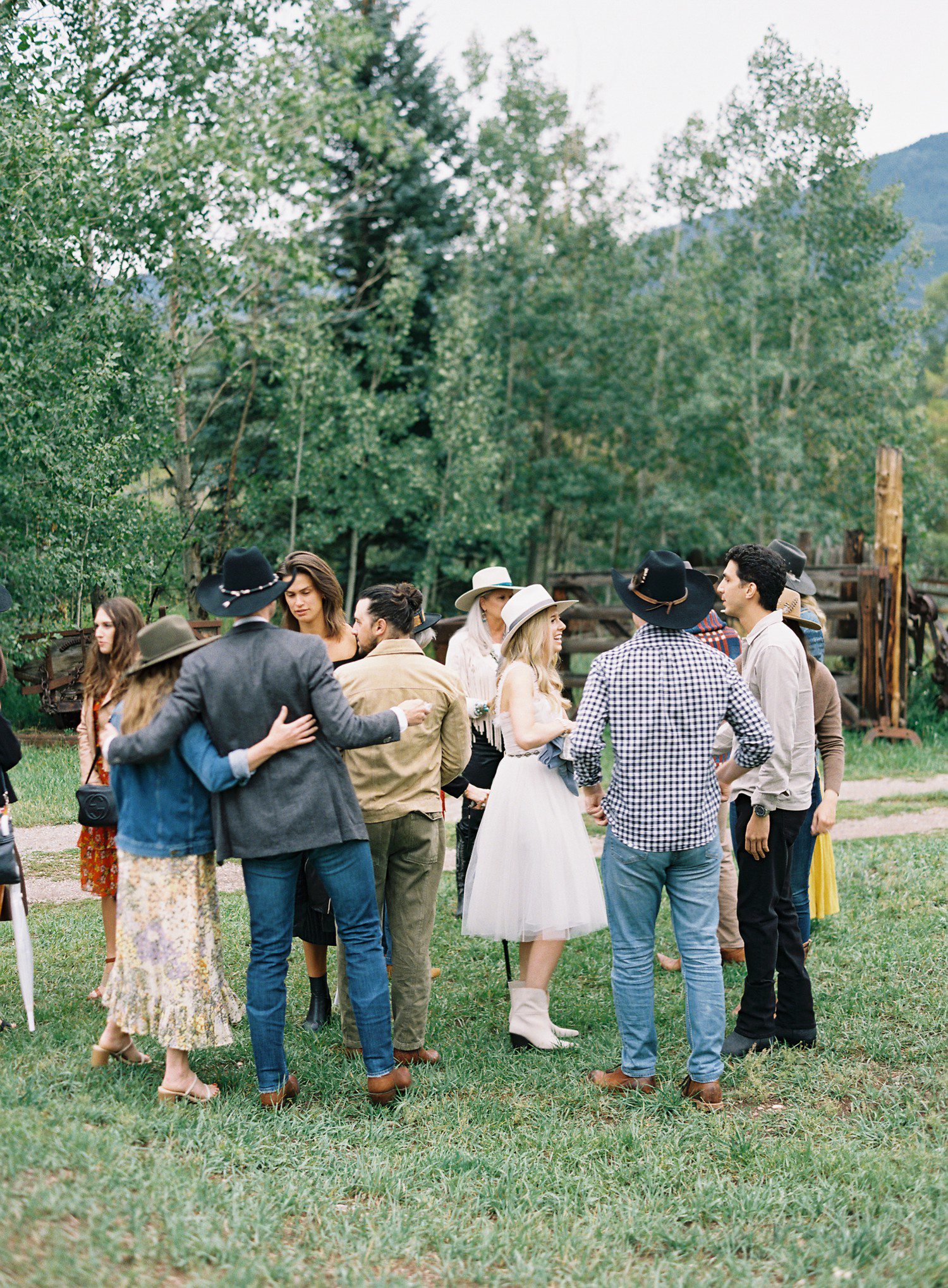 Bride and groom talking to wedding guests at rehearsal in Aspen. 