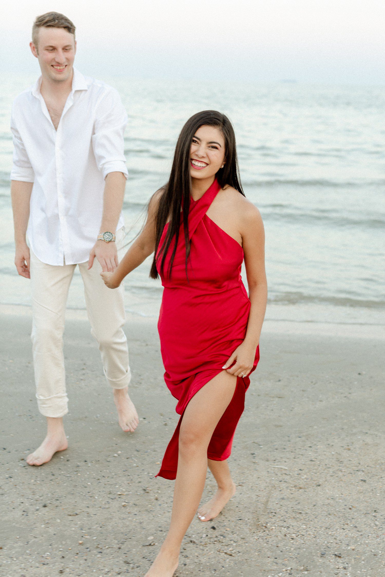 Couple walking on beach for engagement photos in Galveston. 
