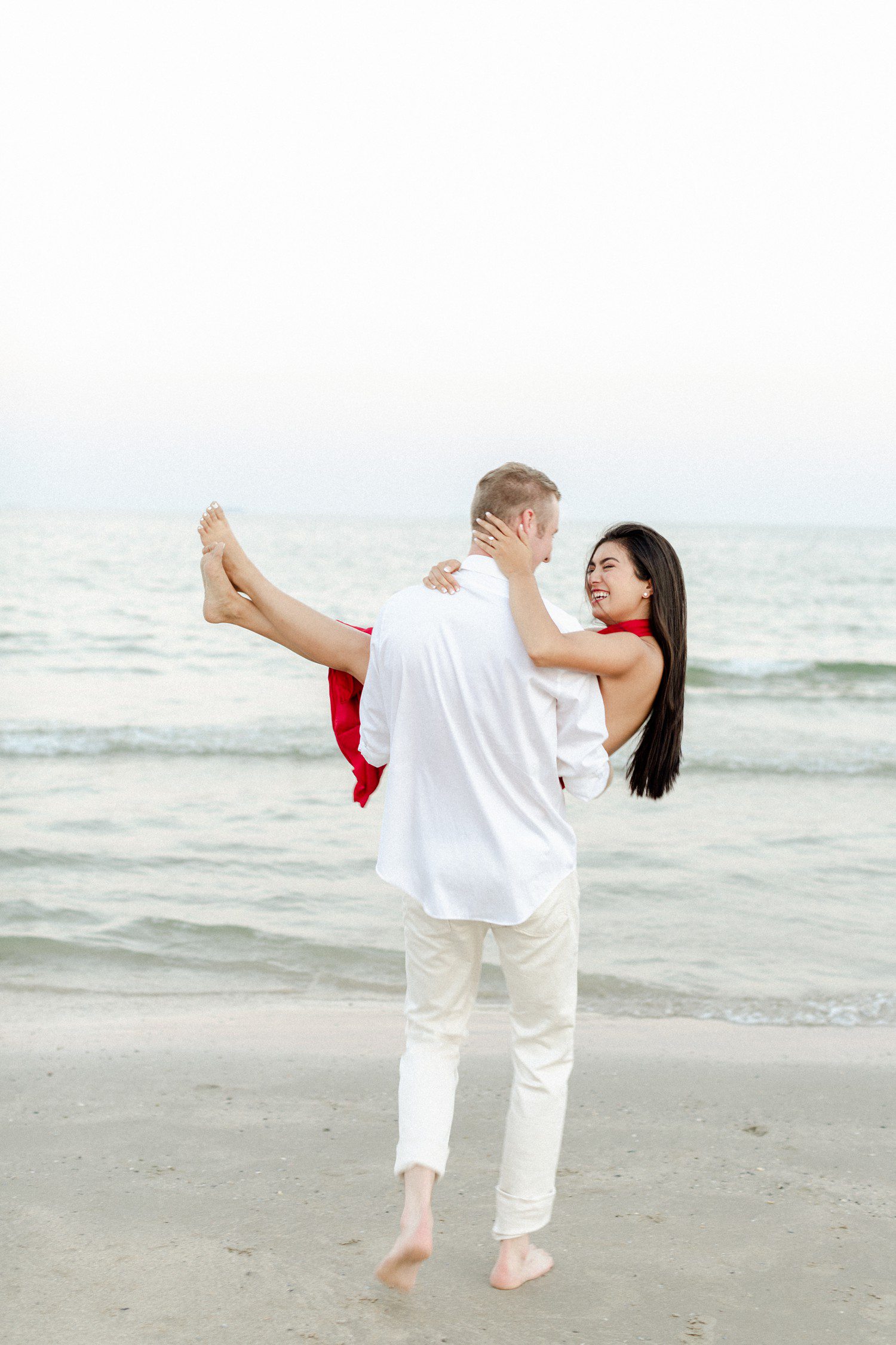 Galveston beach engagement photos with guy picking up girl. 