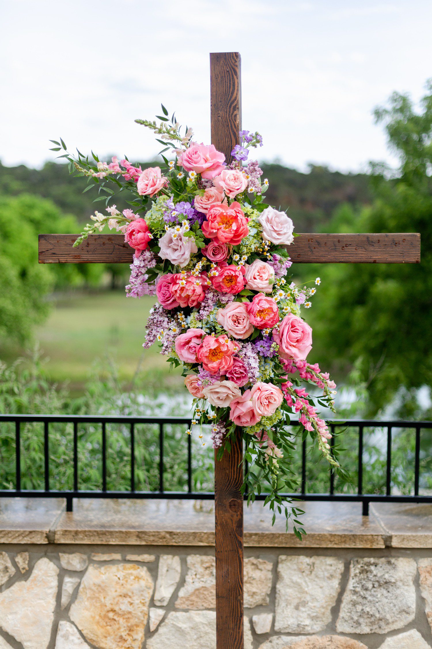 Wedding ceremony cross decorated with flowers.