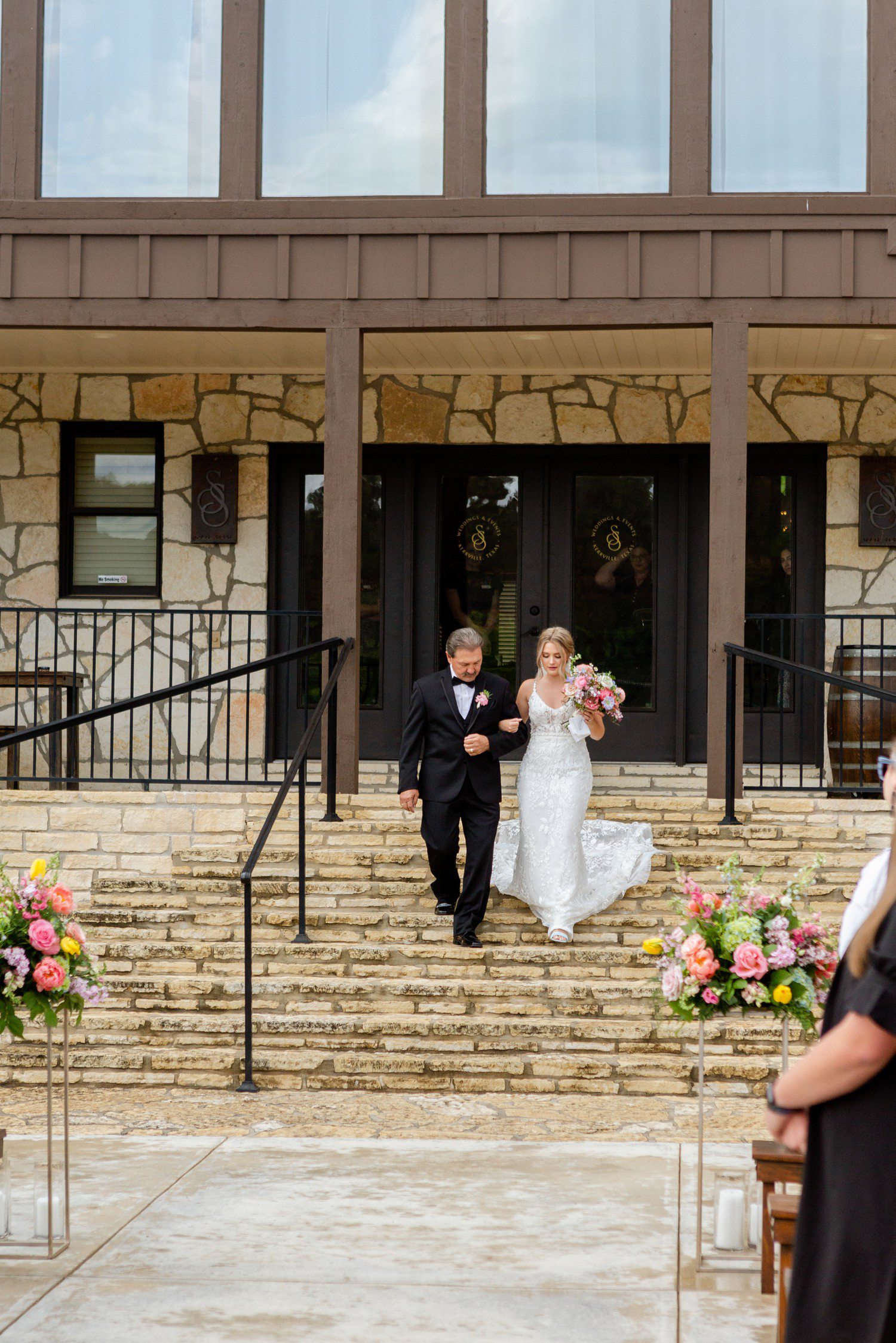 Bride and father walking down the aisle during wedding ceremony at Sendera Springs in Kerrville.