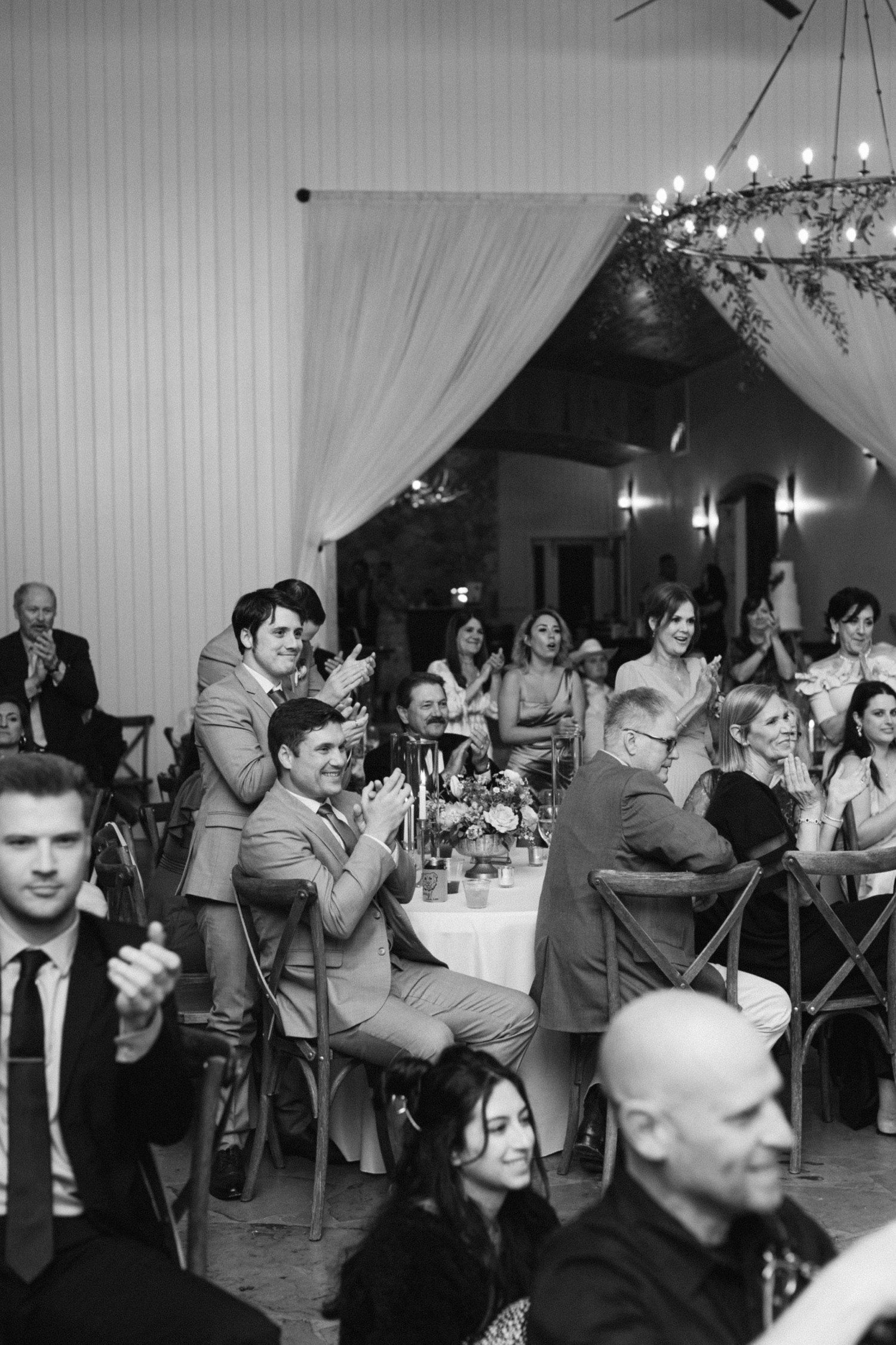 Guests clapping during wedding reception.