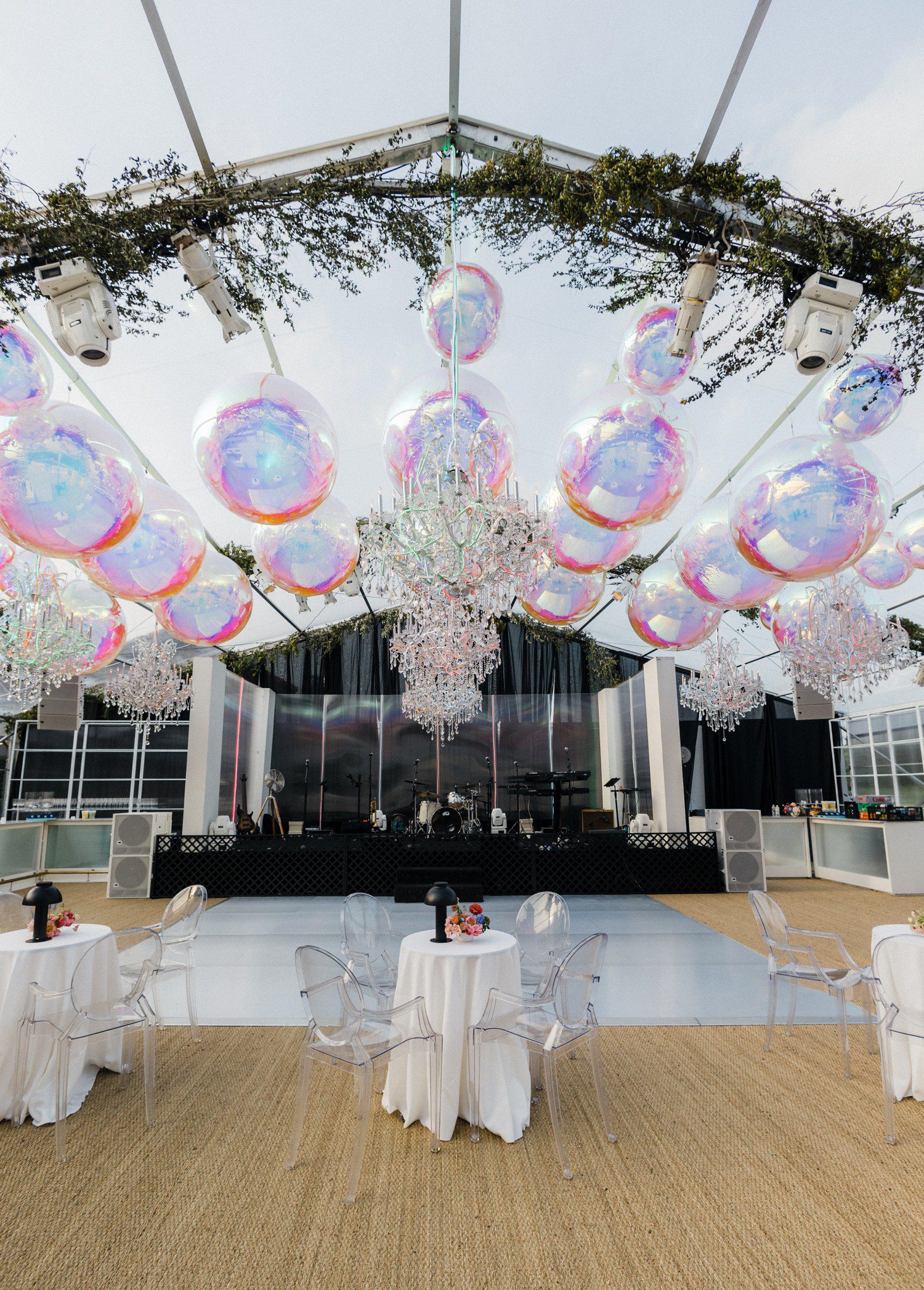 Wedding reception dance floor with chandeliers and balloons.