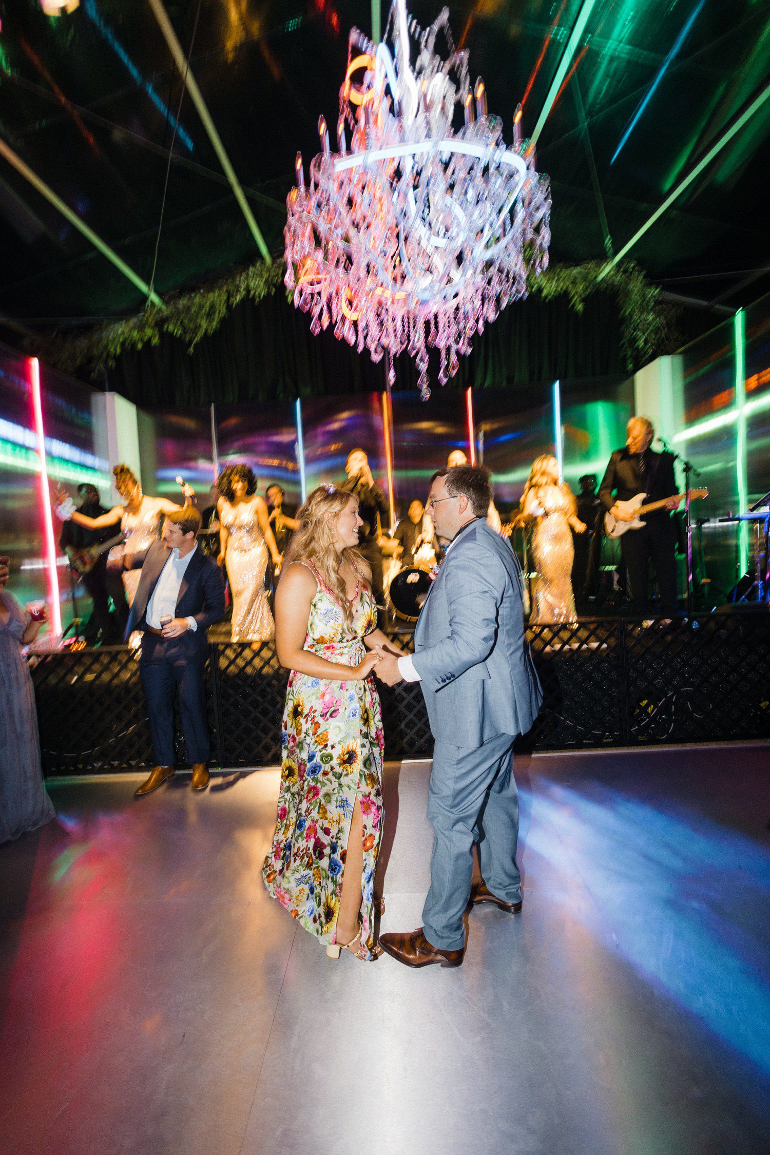 Bride and groom dancing on neon dance floor. 