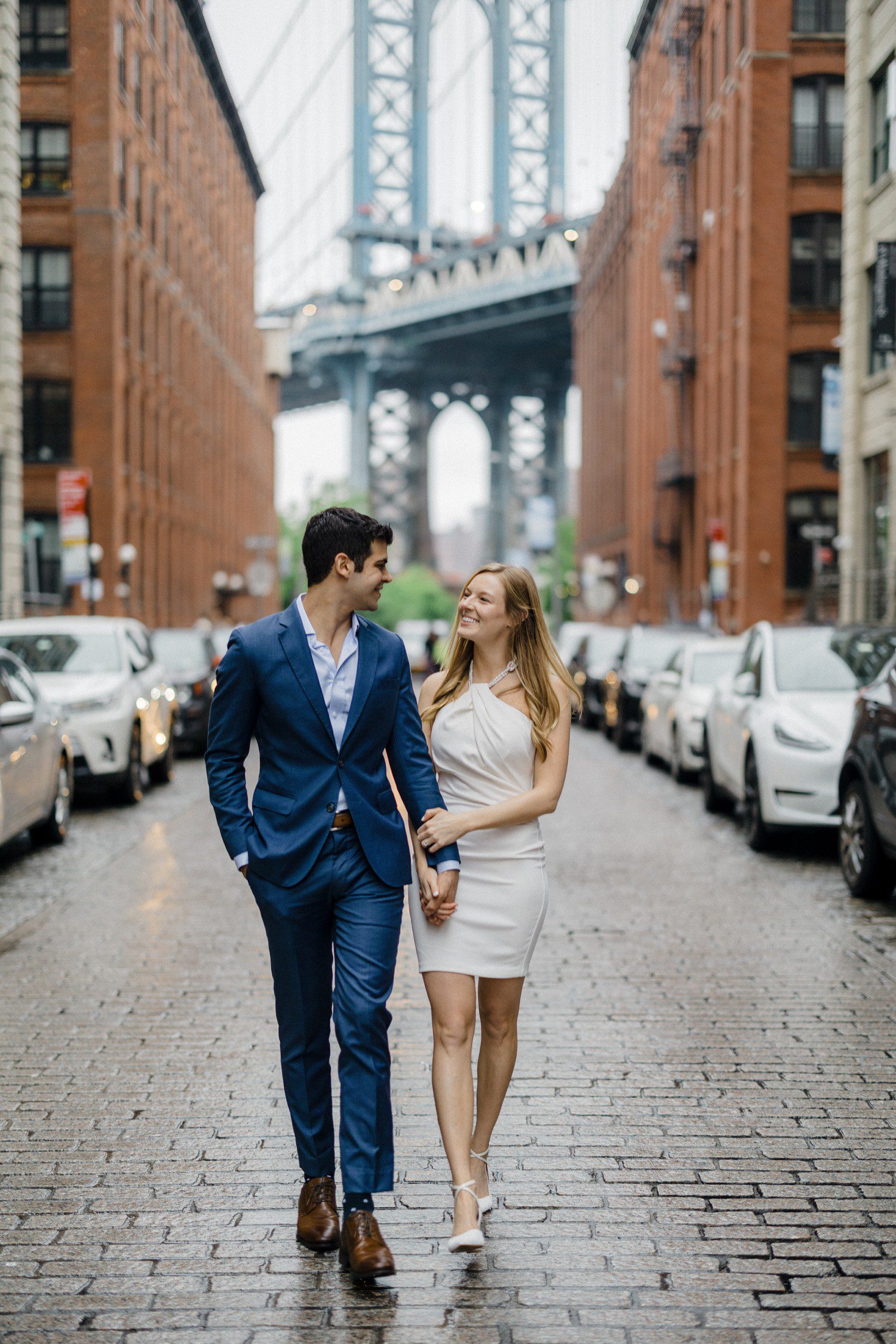 Couple walking during engagement photos at Brooklyn Bridge. 