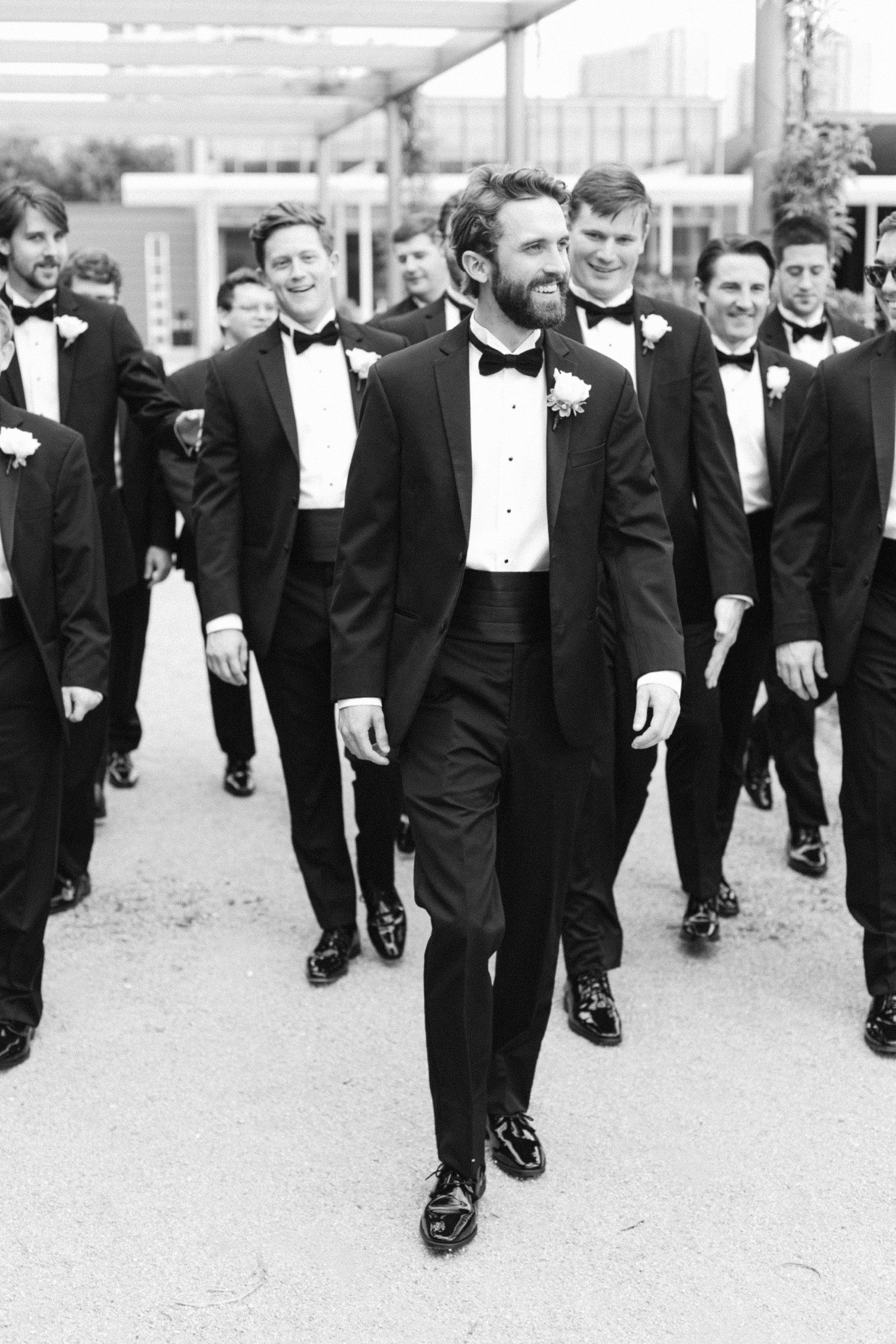 Groom walking with groomsmen at Houston Centennial Gardens. 