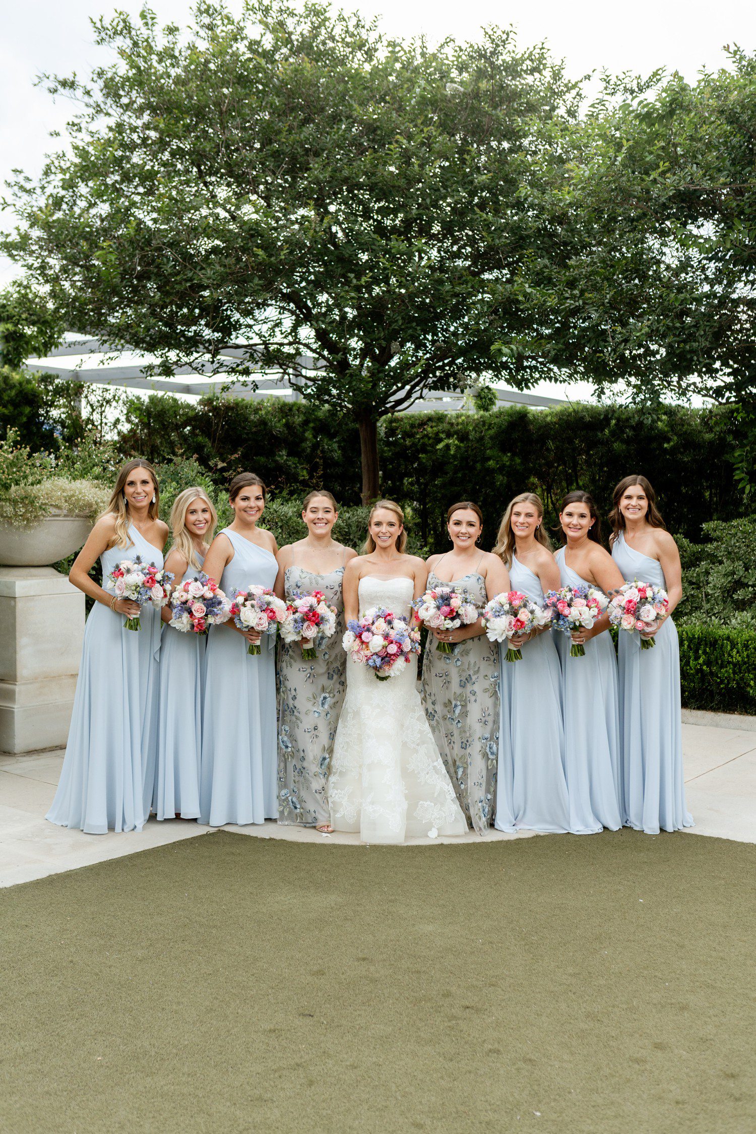 Bride with bridesmaids in light blues dresses at Centennial Gardens in Houston. 