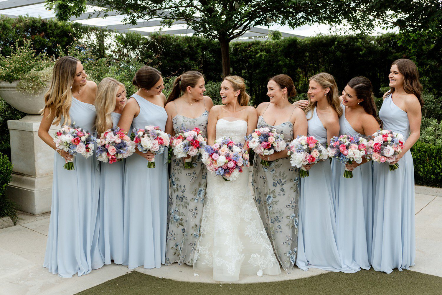 Bride laughing with bridesmaids for photos at Houston's Centennial Gardens. 