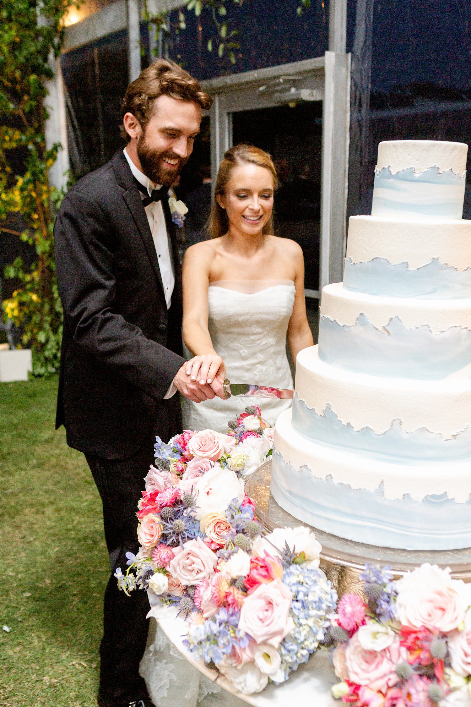 Bride and groom cutting blue wedding cake. 