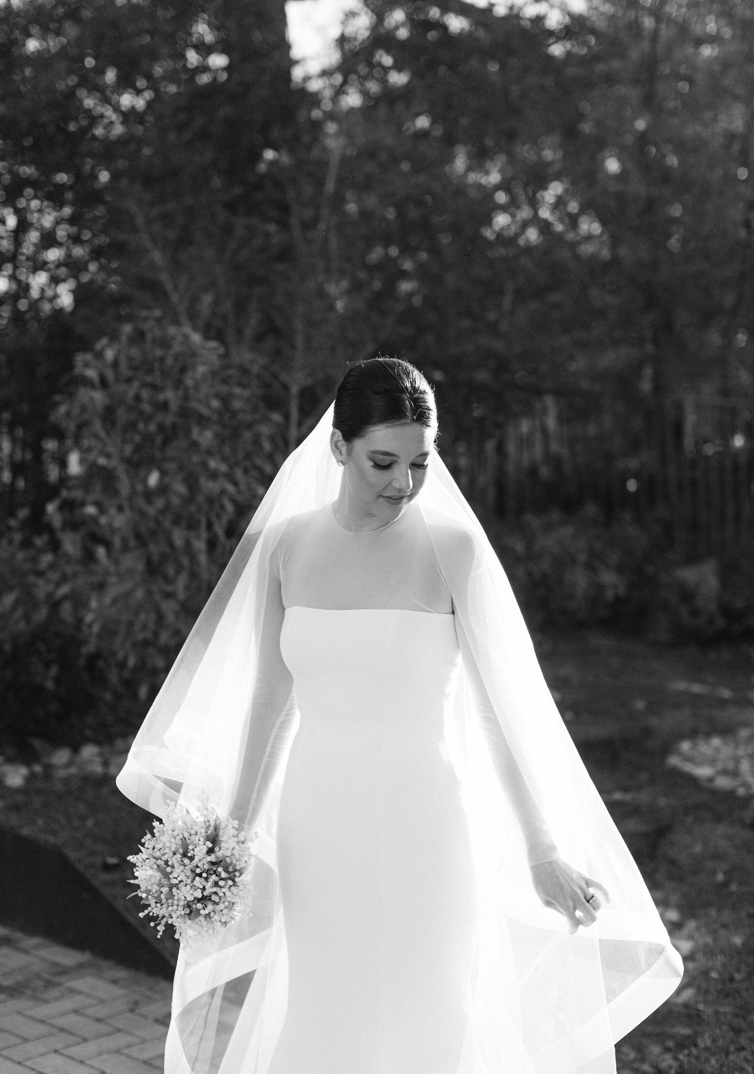Bride in long sleeve wedding dress and veil during bridal portraits. 