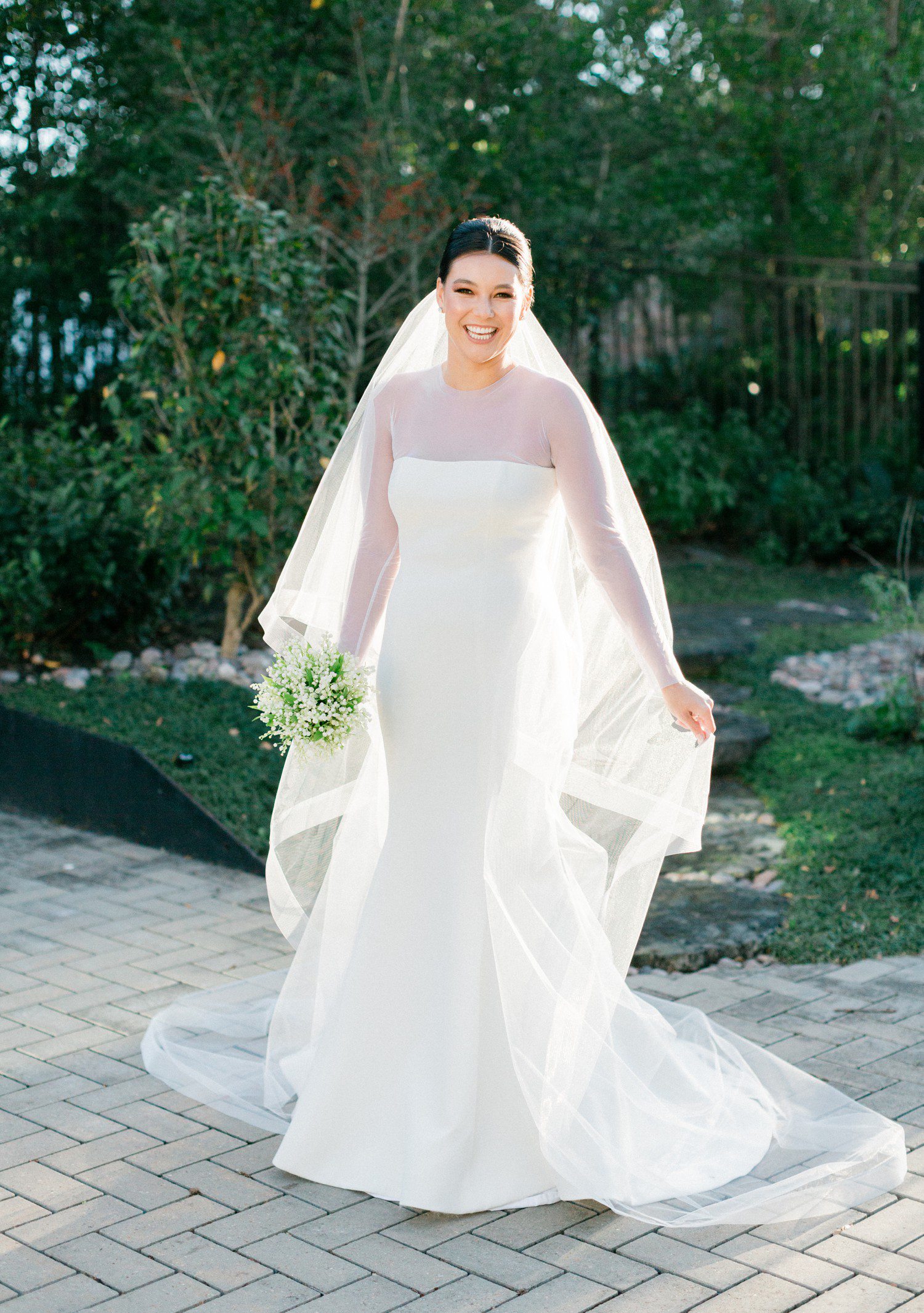 Bride wearing long sleeve wedding dress and veil for bridal portraits in Houston. 