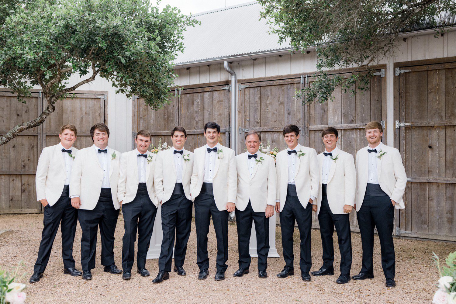 Groomsmen in white suit jackets at The Compound. 
