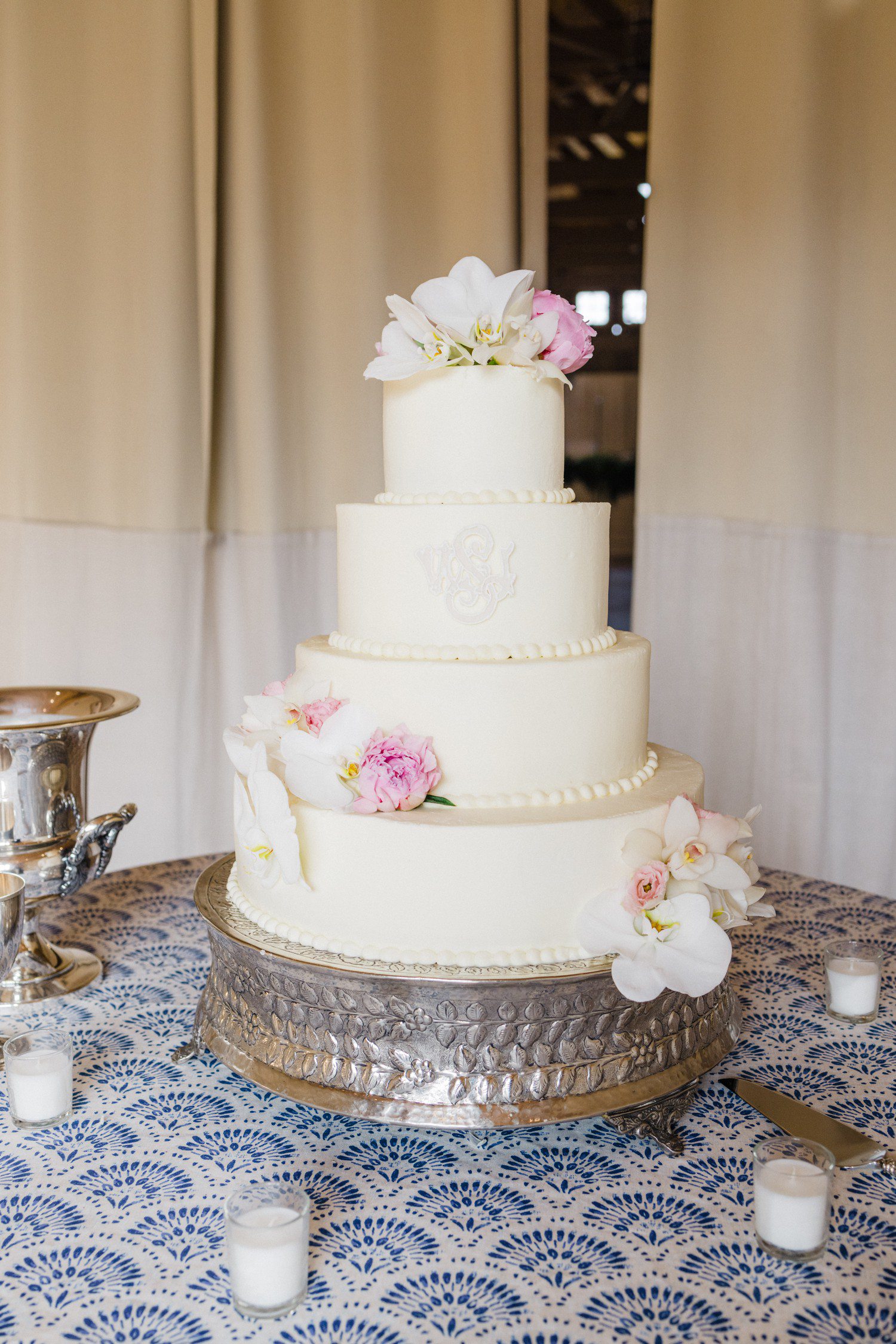 Three tier white wedding cake with white wedding crest. 