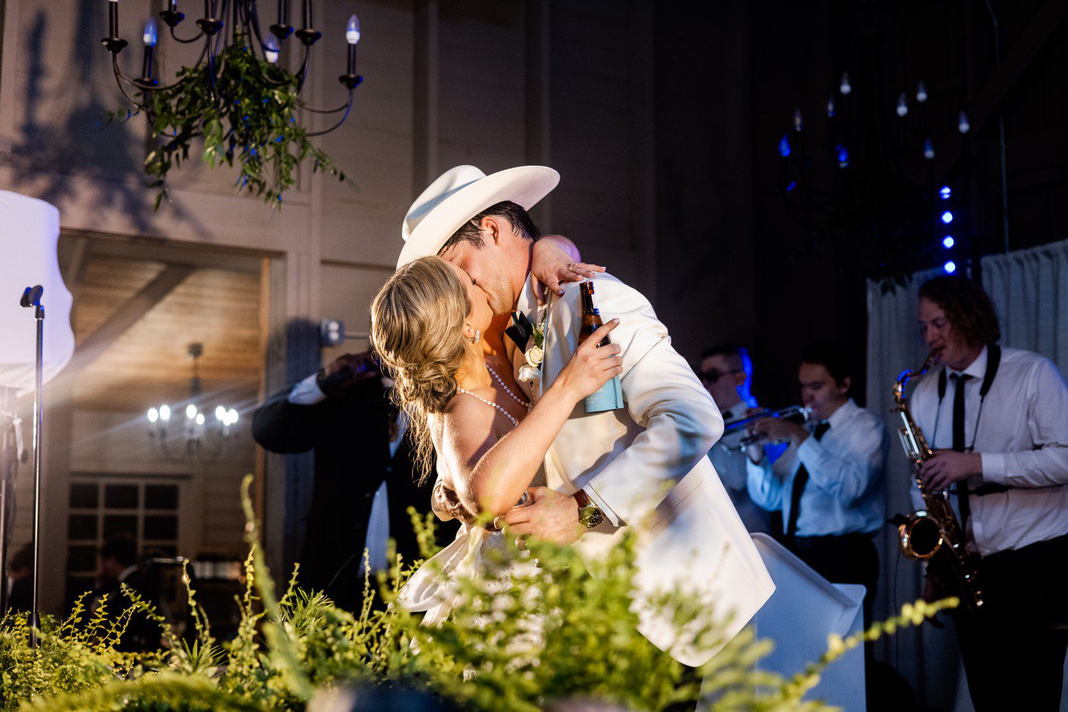 Bride and groom kissing at wedding reception. 
