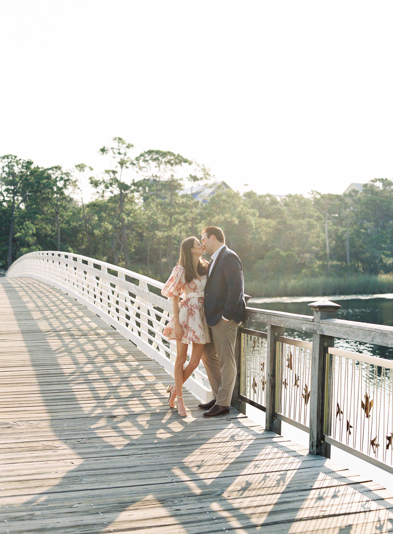 Couple kissing for engagement photos on bridge in Watercolor, FL. 