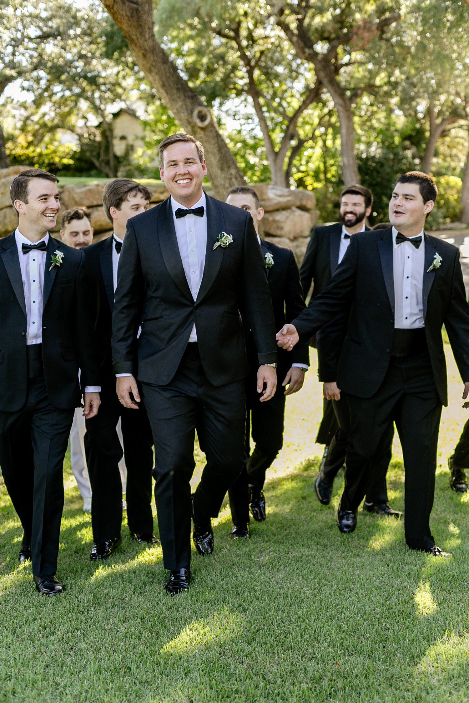 Groom walking with groomsmen at Austin Country Club.