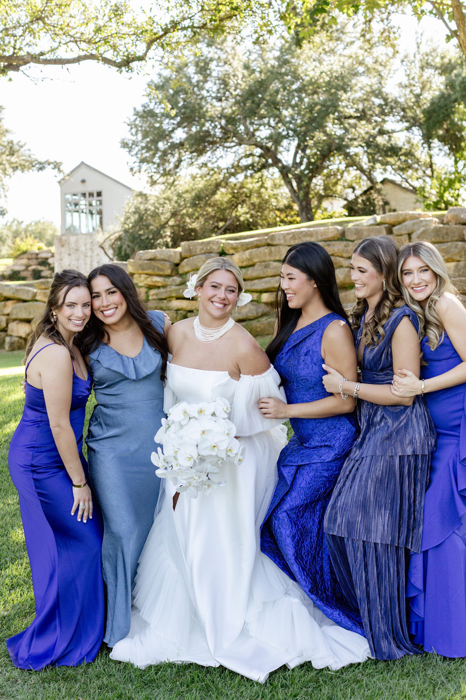 Bride with bridesmaids in blue bridesmaid dresses.