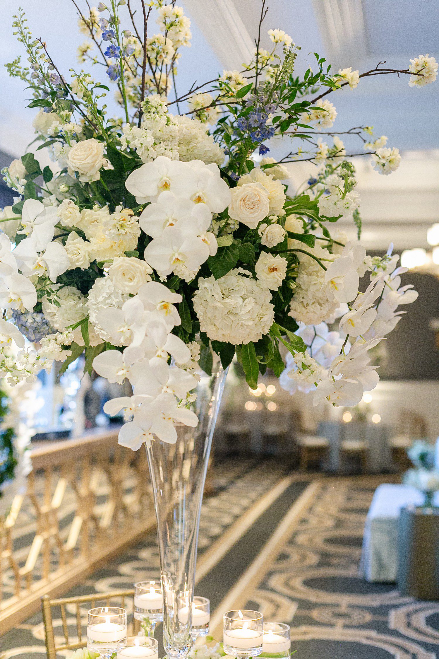White orchid and white flowers for wedding reception table centerpiece.