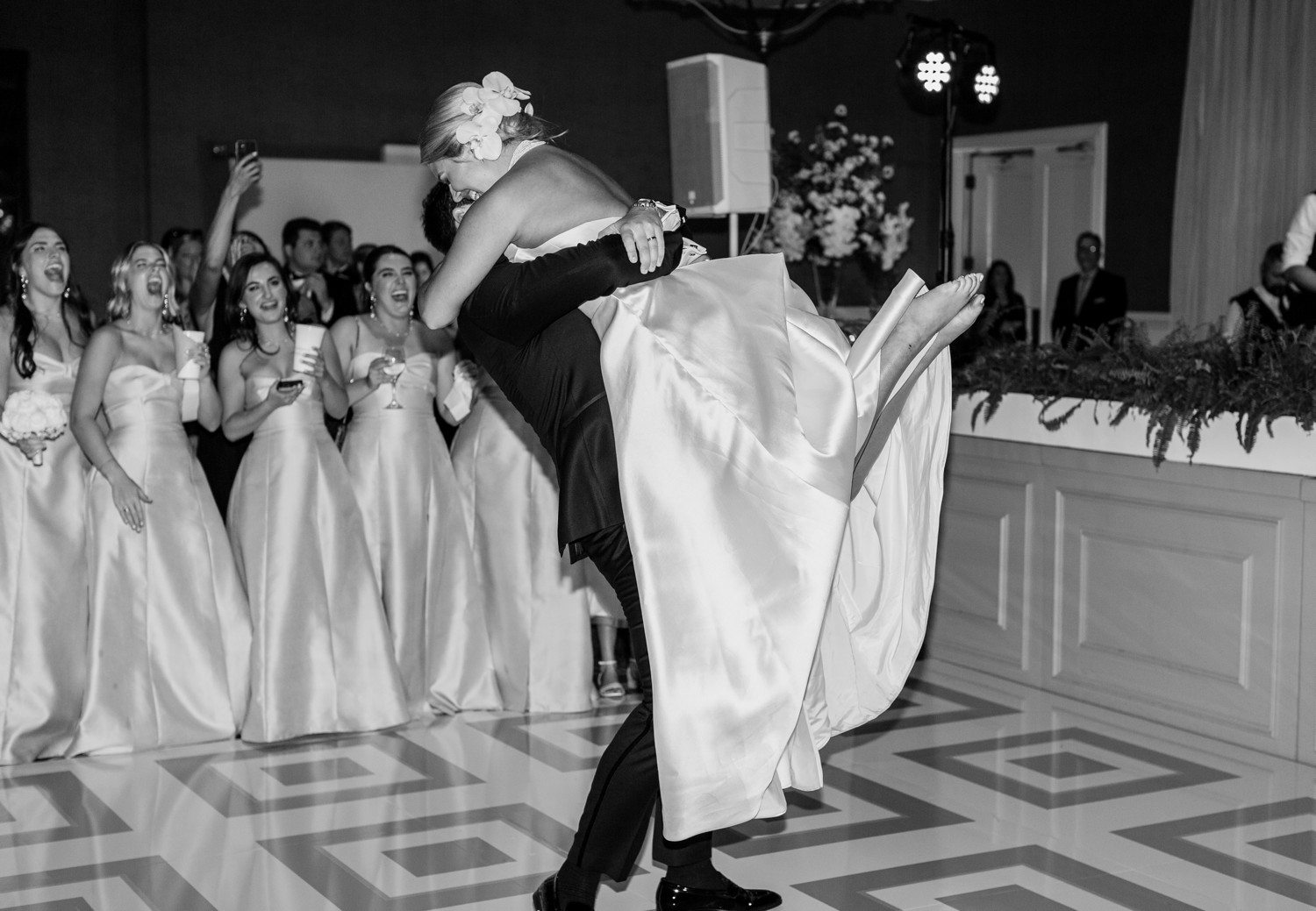Groom picking up bride during wedding first dance.