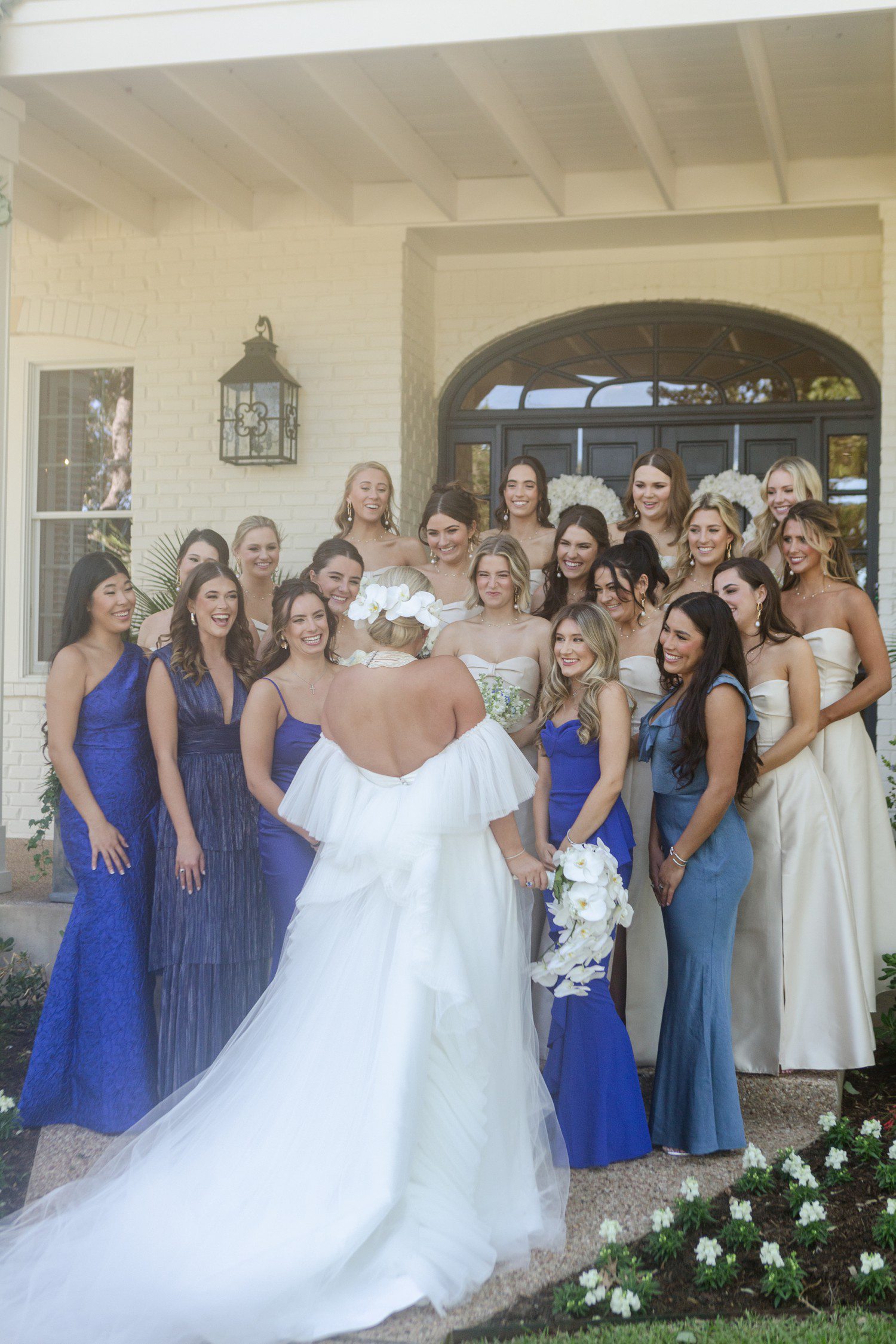 Bride surrounded by bridesmaids smiling at her.