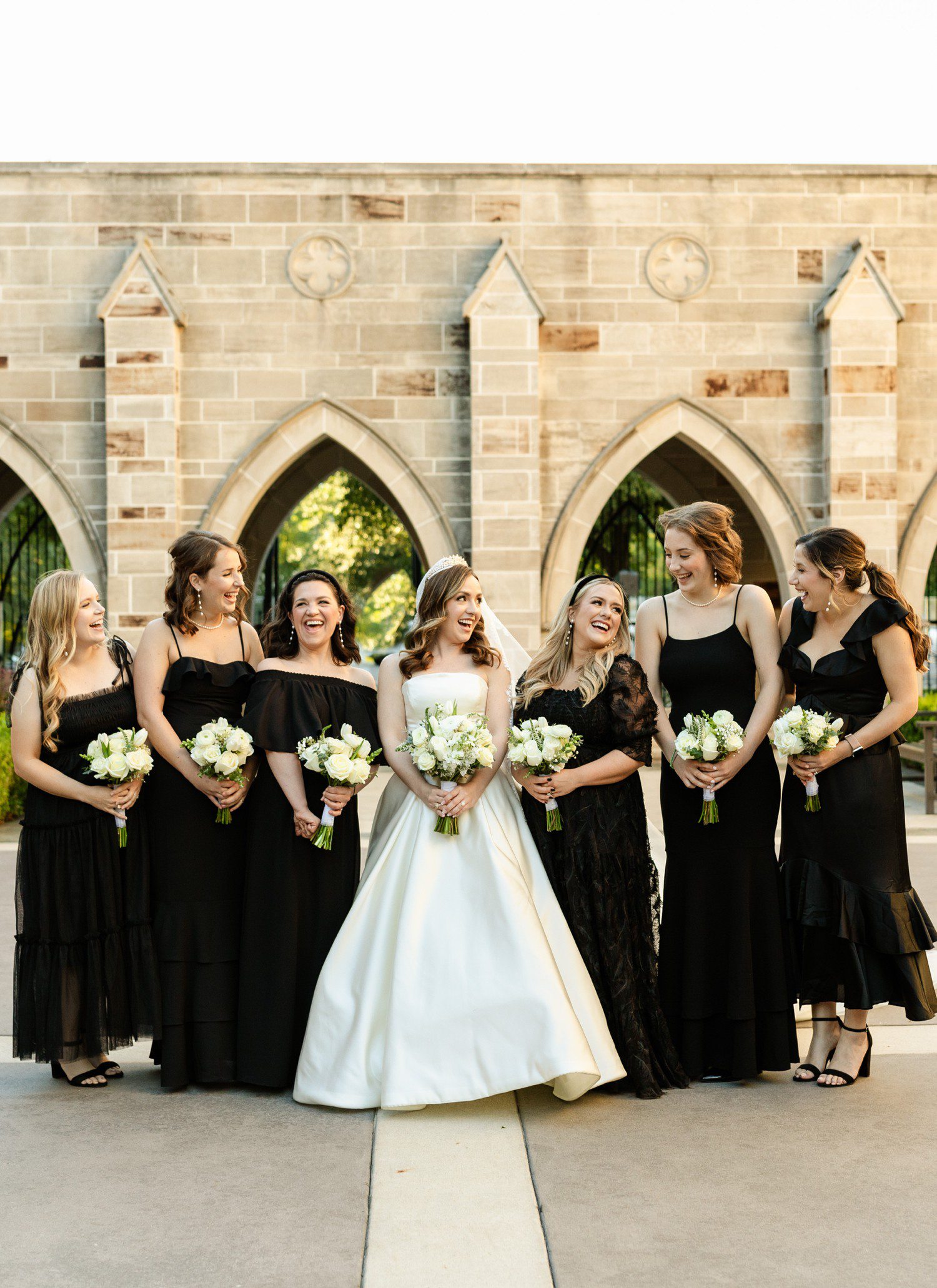 Bride and bridesmaids in all black dresses at Holy Rosary Church.