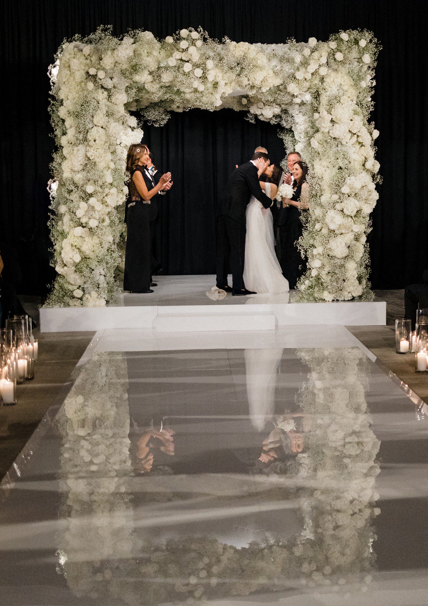 Wedding ceremony at Four Seasons in Austin TX beneath chuppah covered in flowers. 