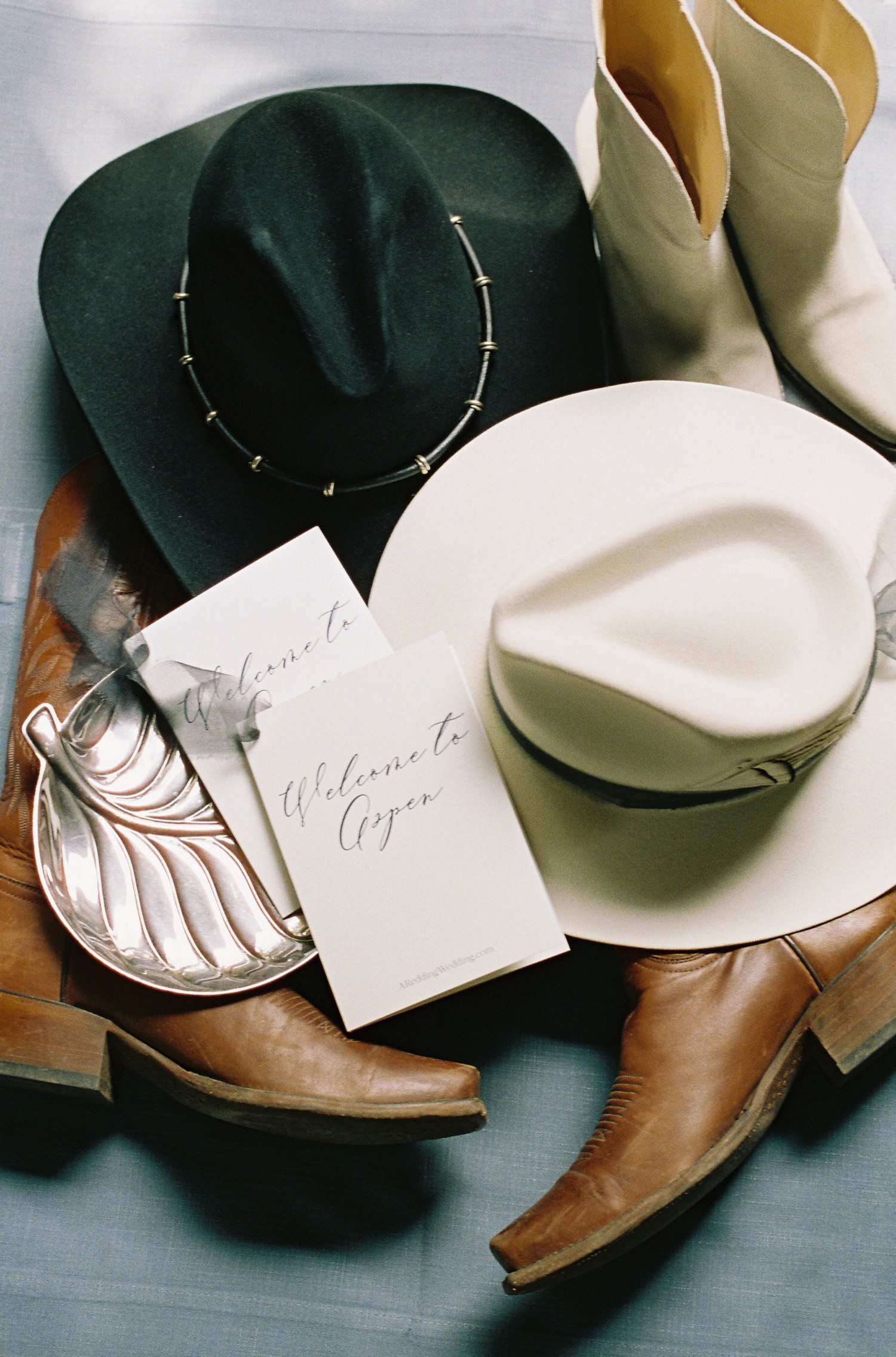 Aspen wedding flat lay with cowboy boots and cowboy hats. 