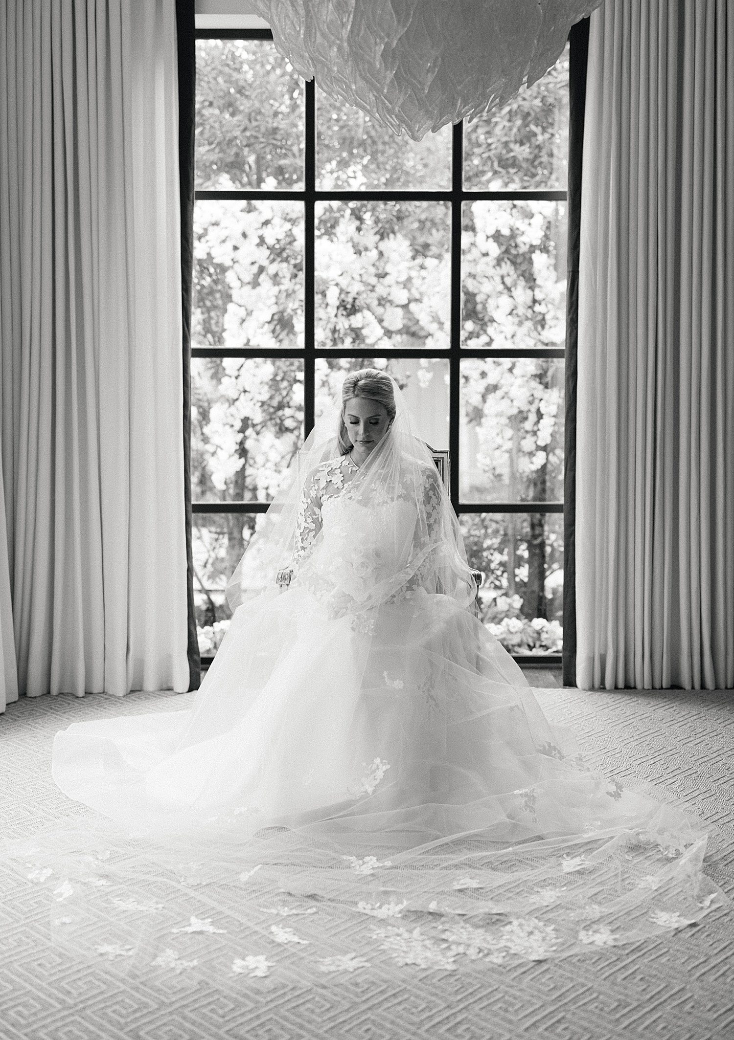 Black & white photo of bride in front of window