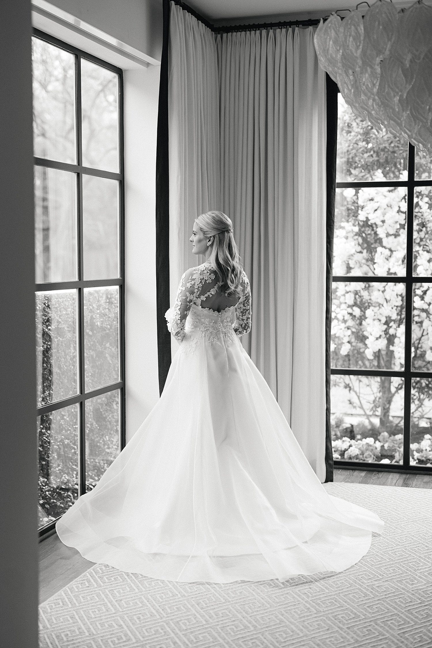 Black & white photo of bride in front of window