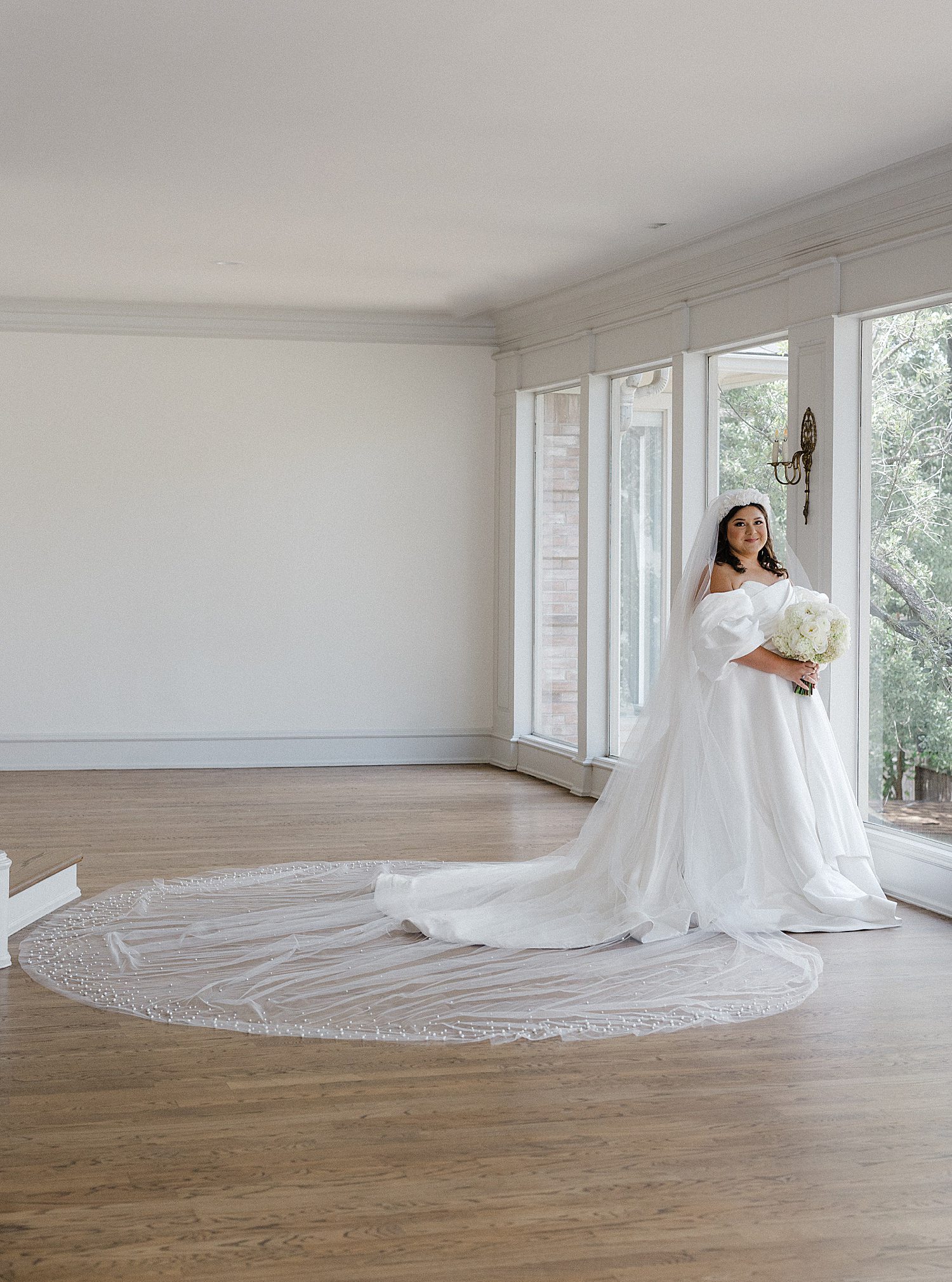 Bride with long veil and train spread out behind her