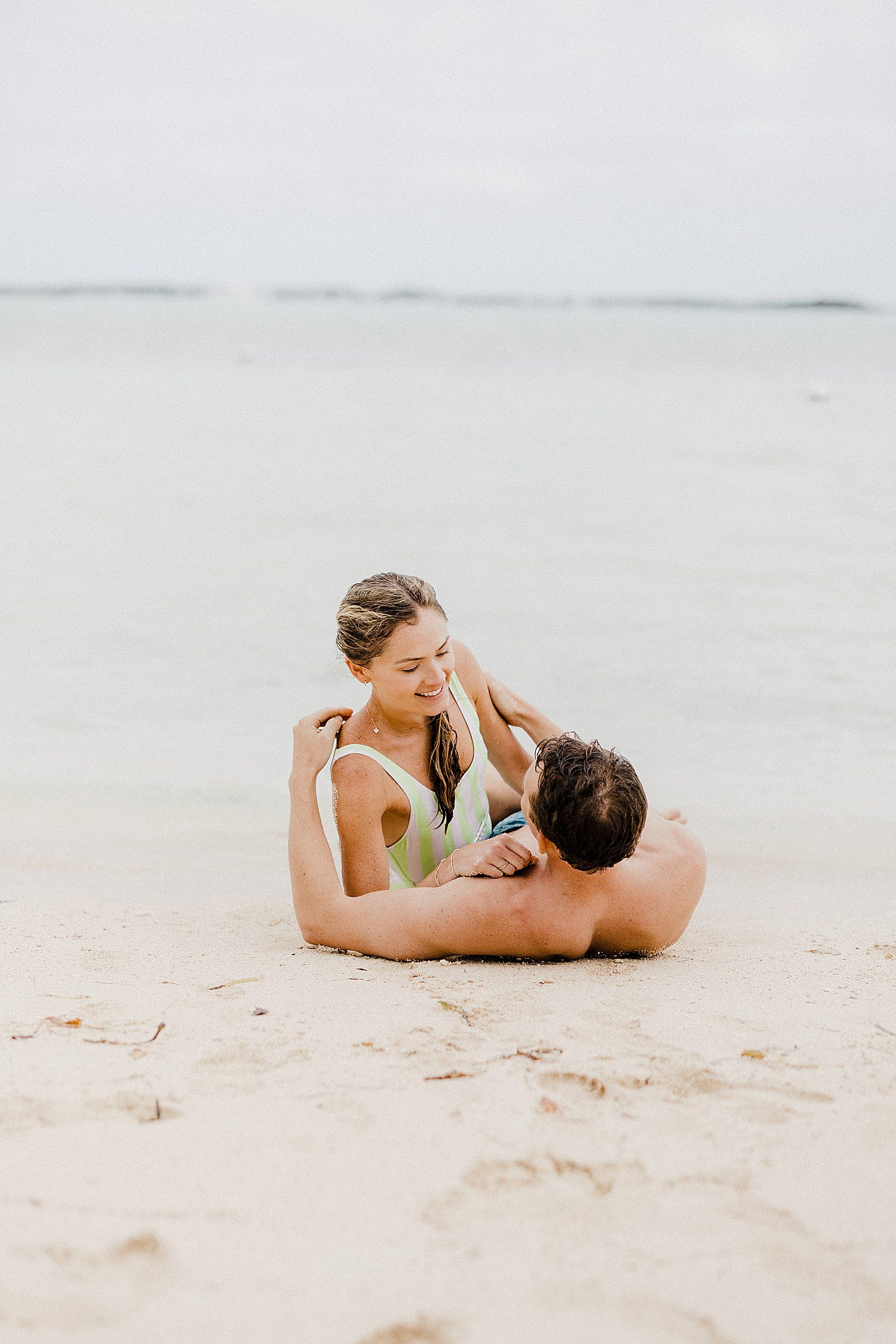 couple laying on the beach together during their honeymoon