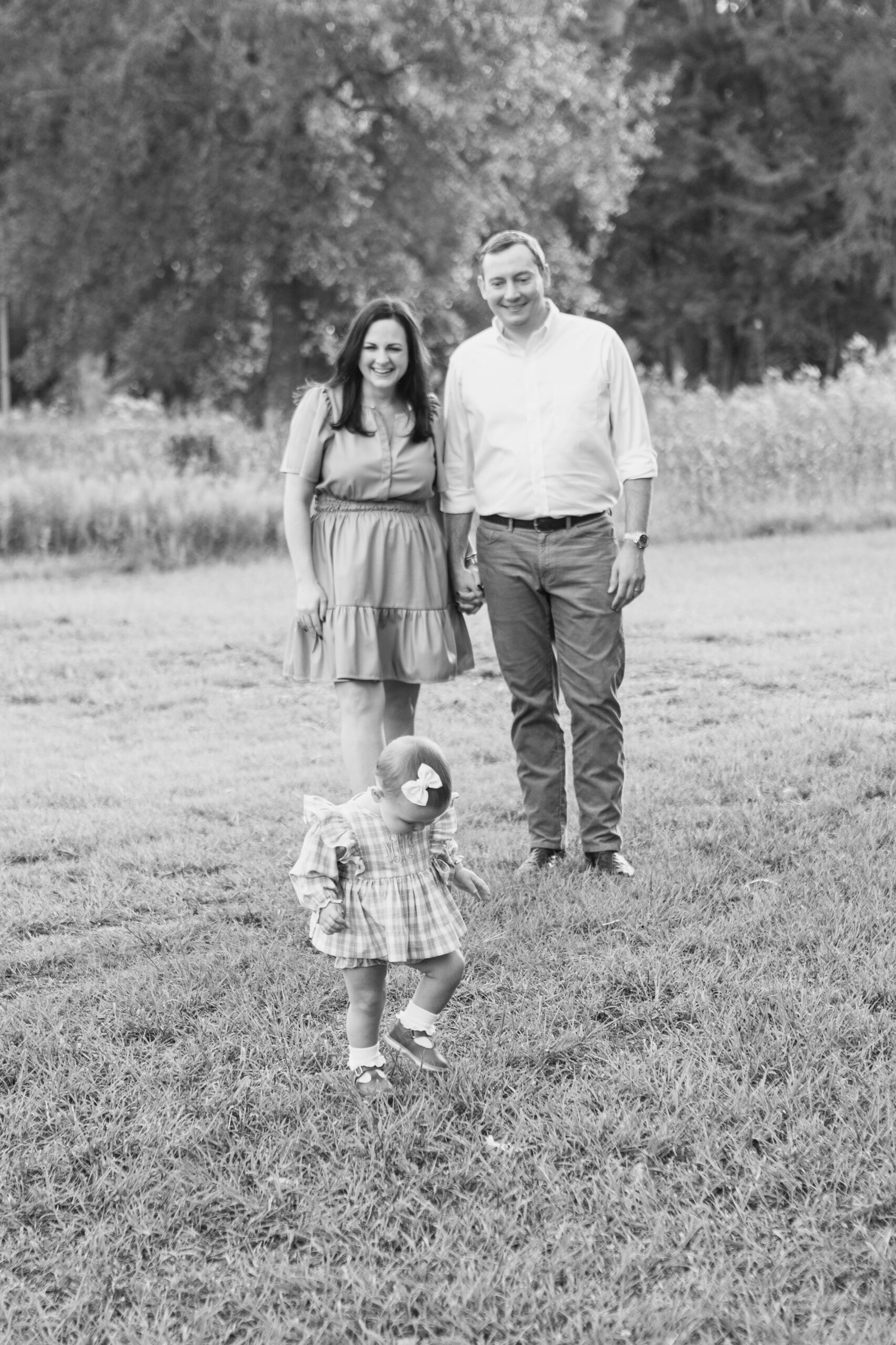 Baby walking in front of parents in park