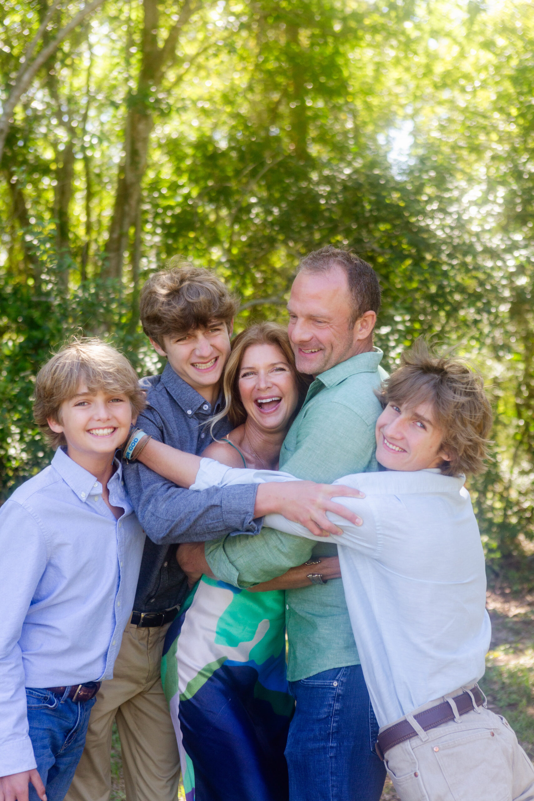 Dad and sons hugging mom and laughing