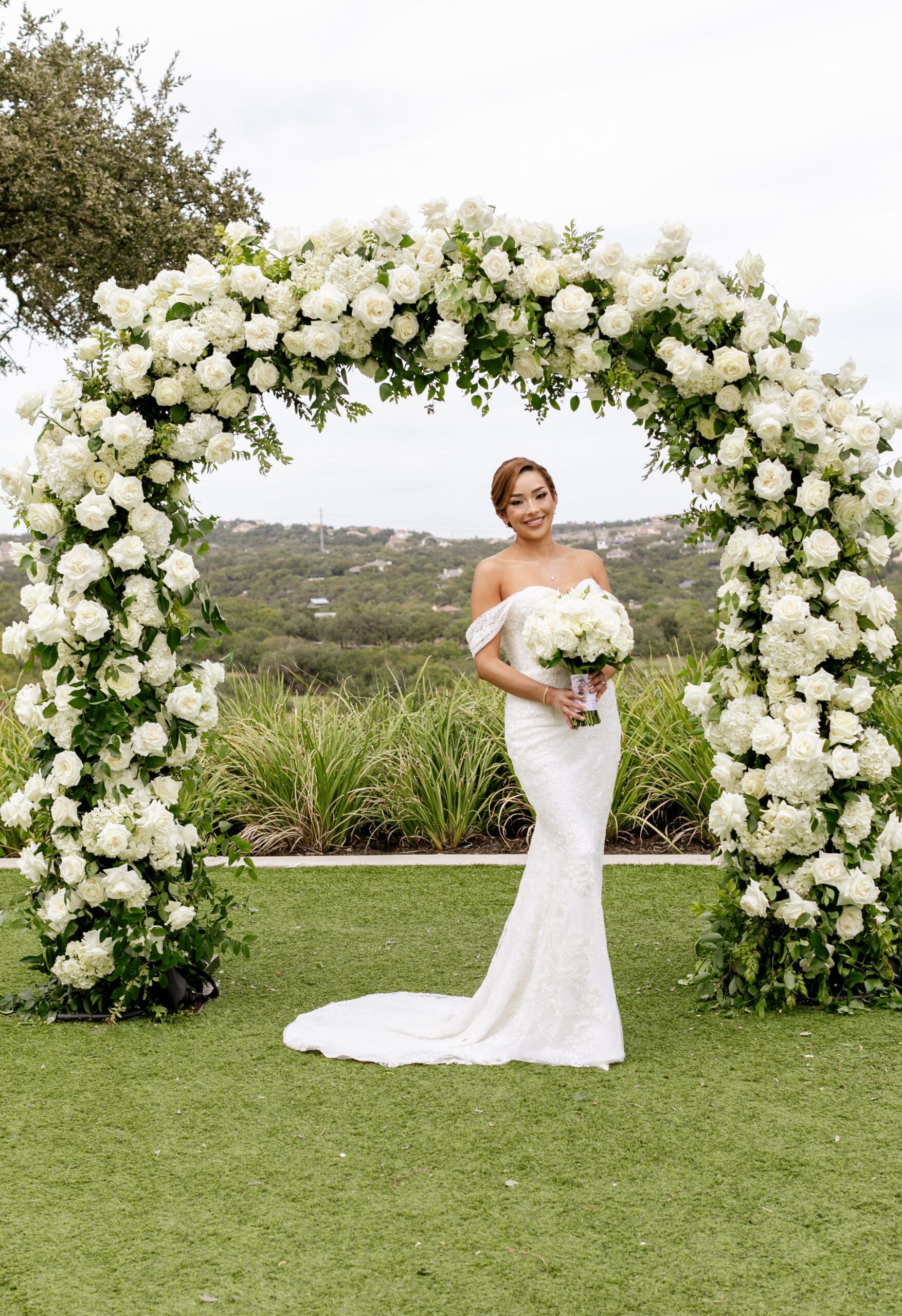 Bride standing in front of floral arch