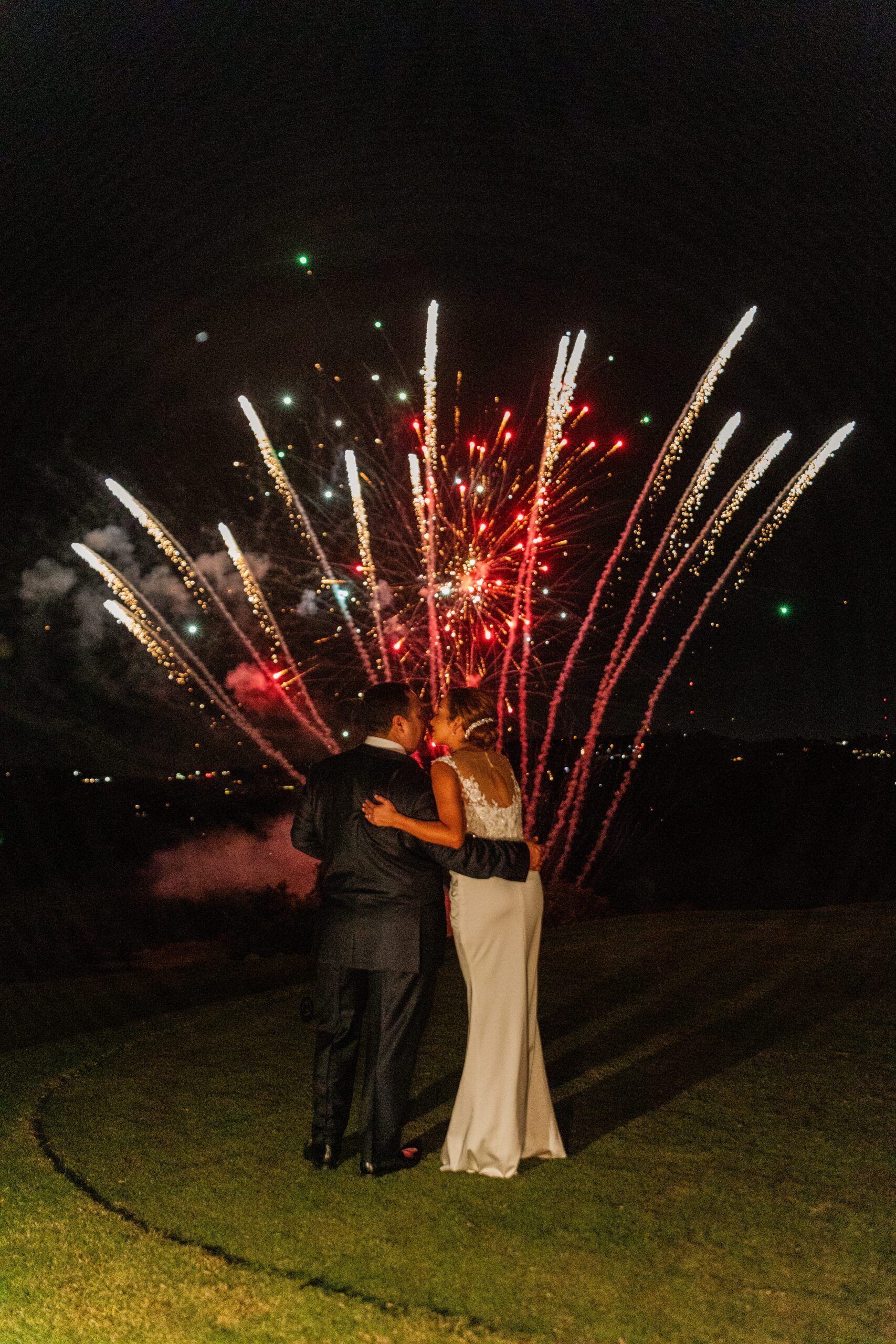 Bride & groom watching fireworks at wedding reception