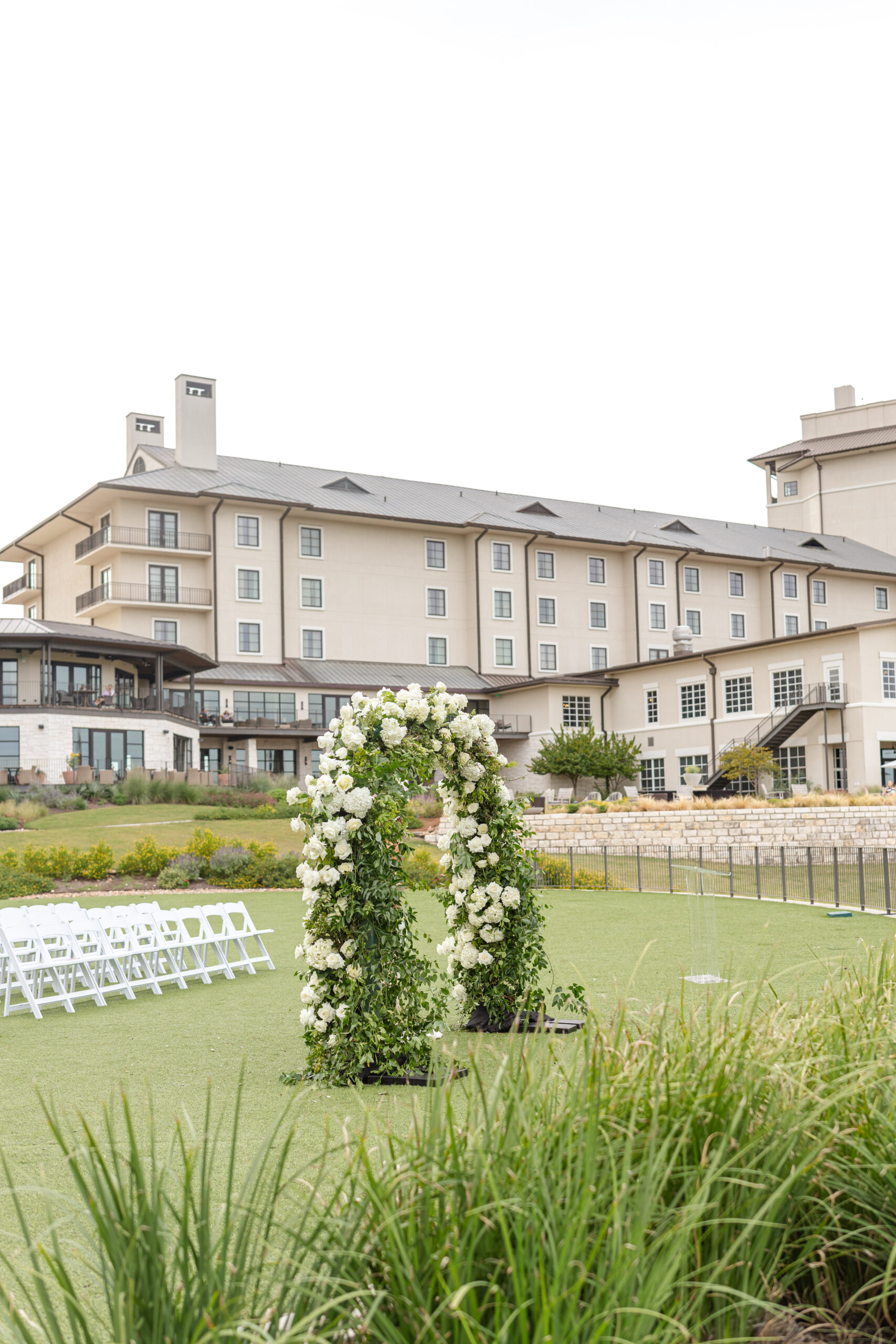 White flower arch at outdoor wedding ceremony