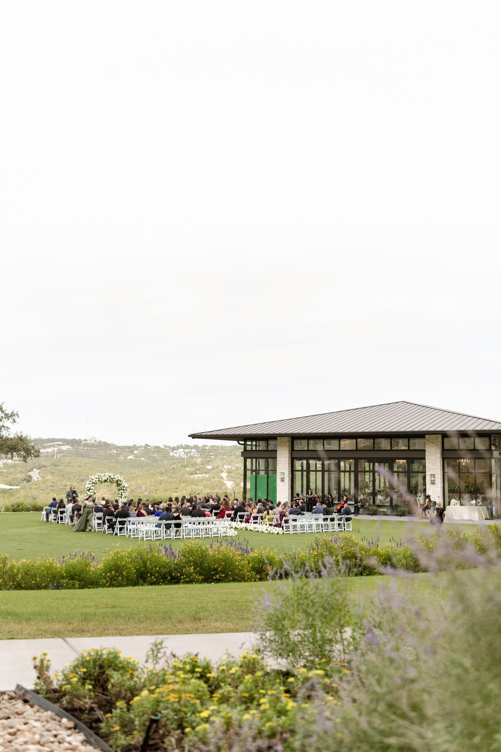 Distant view of outdoor wedding ceremony guests