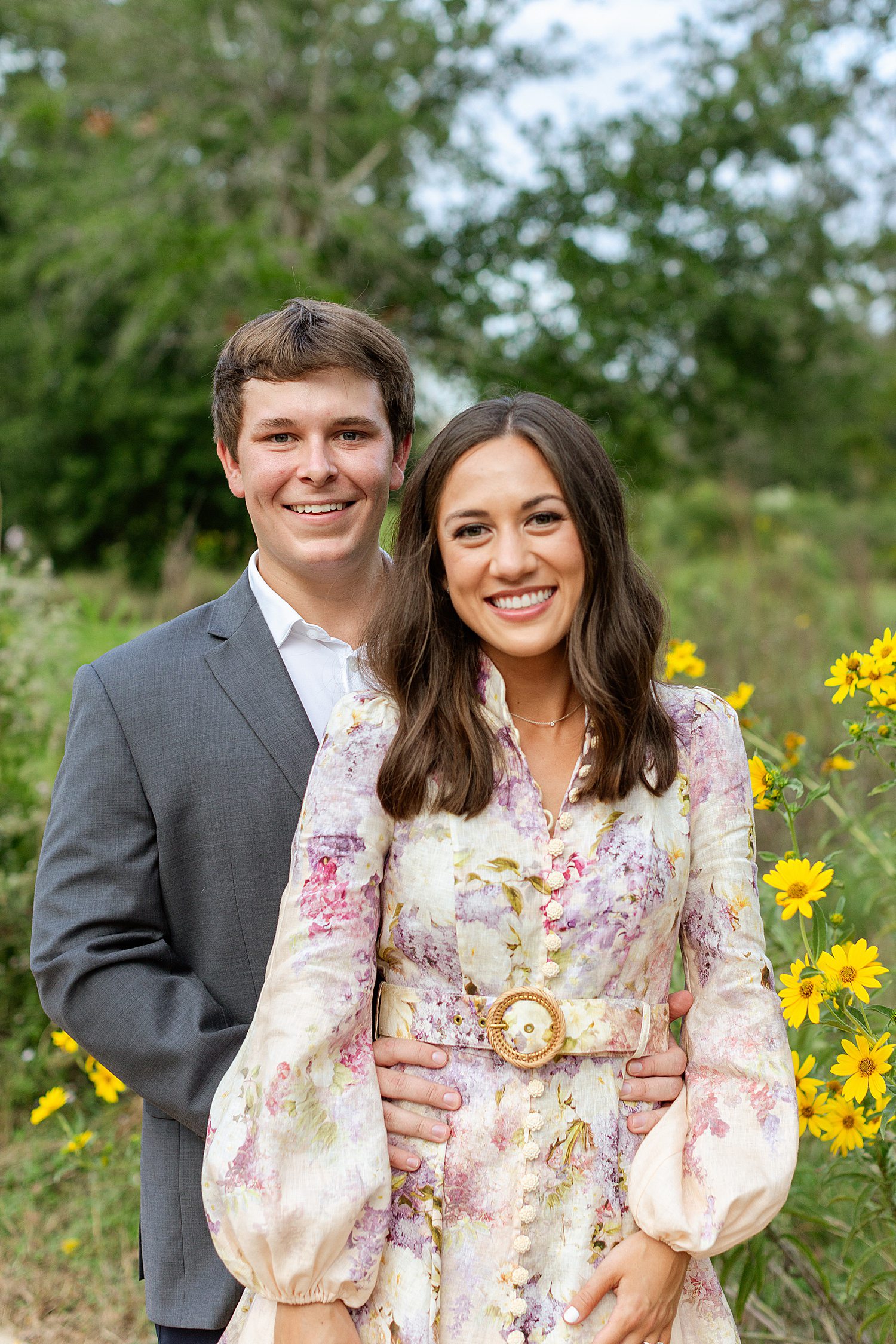 Engaged couple surrounded by yellow wildflowers