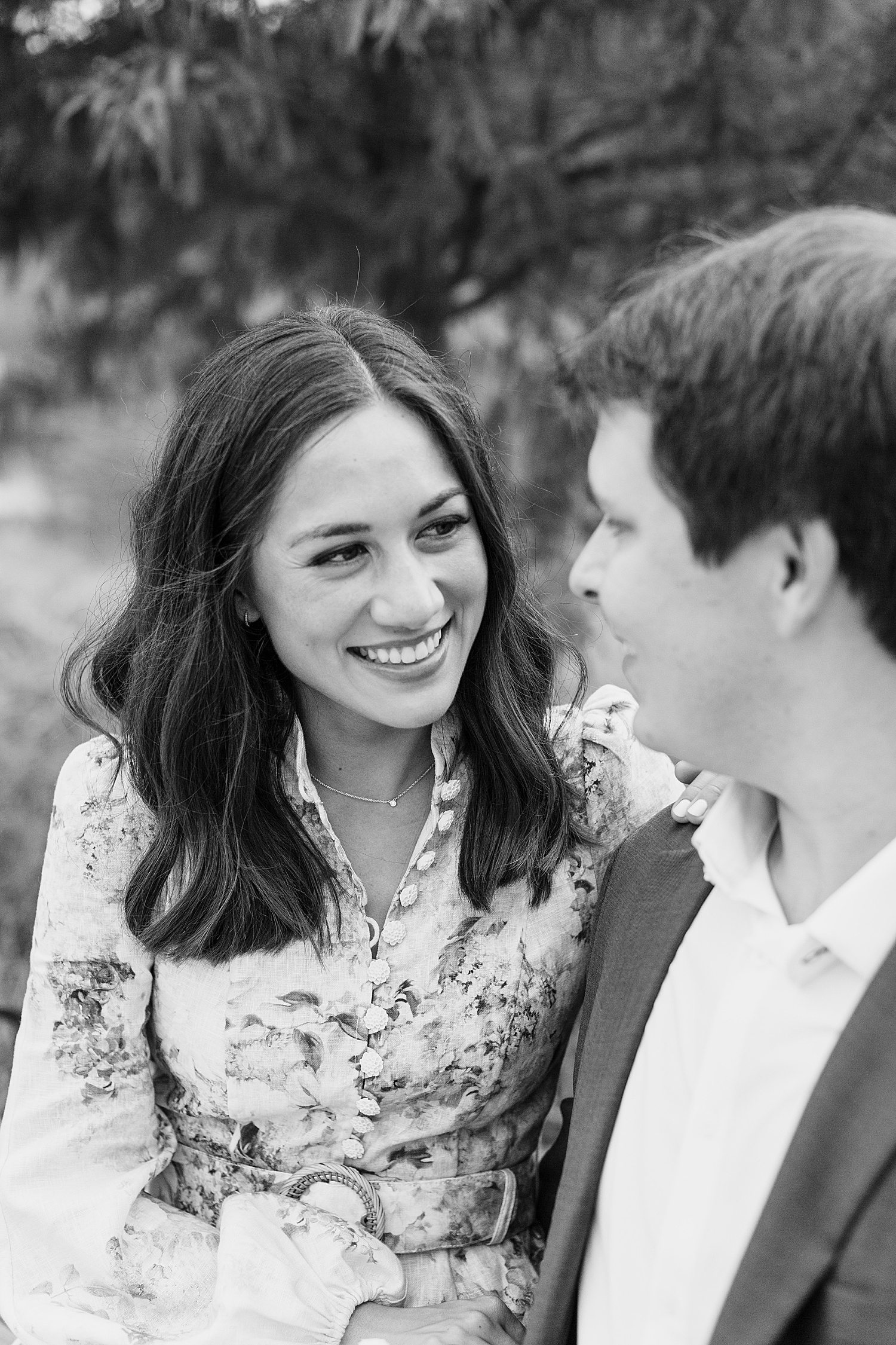 Black & white photo of engaged couple smiling at each other