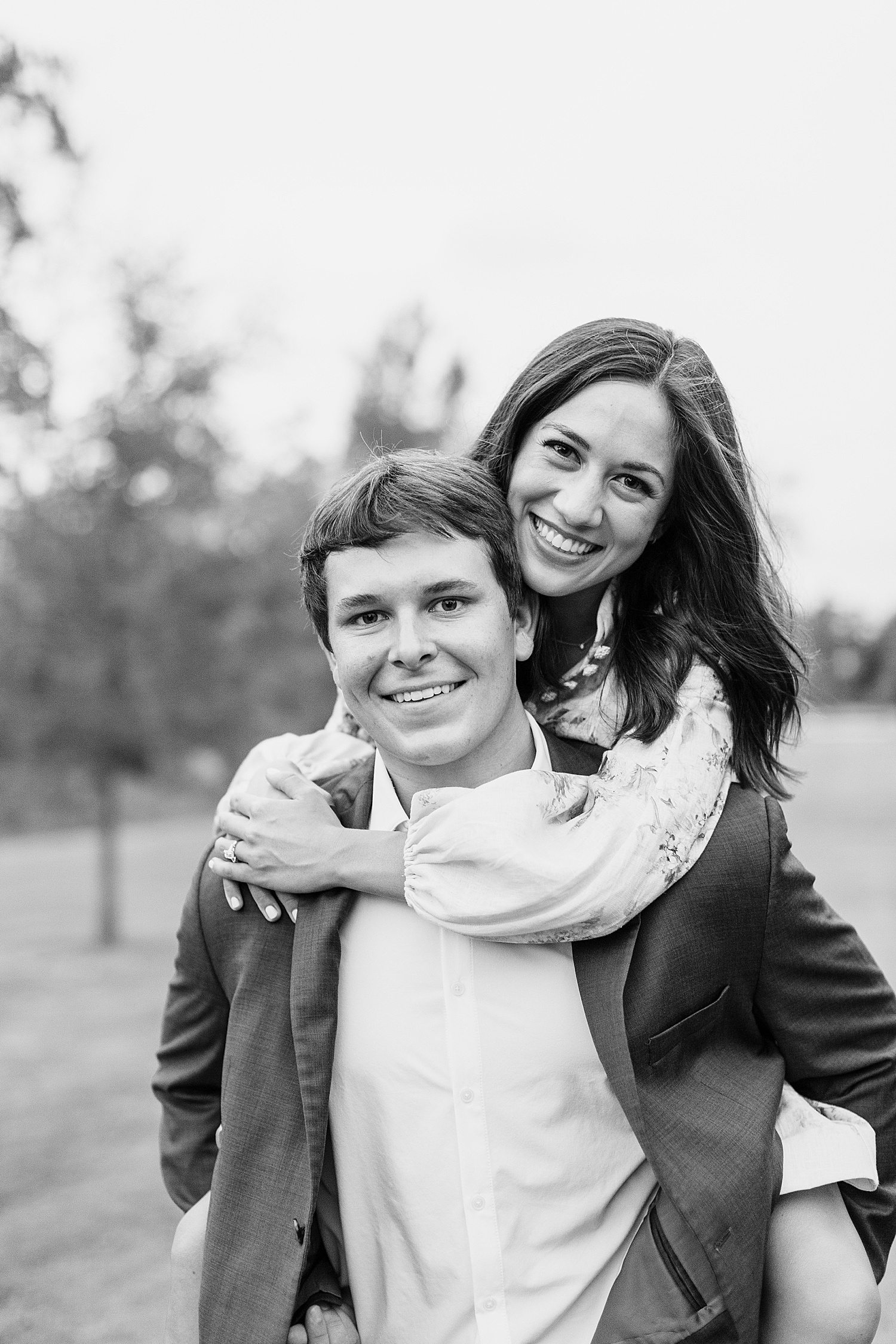 Man carrying his fiancé on his back for engagement photos