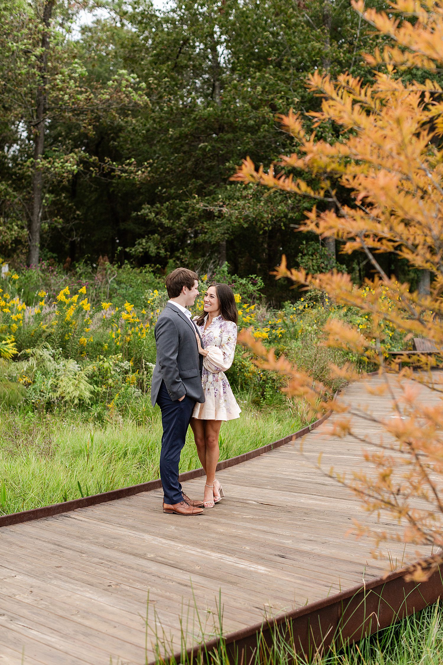 Engaged couple standing among fall foliage