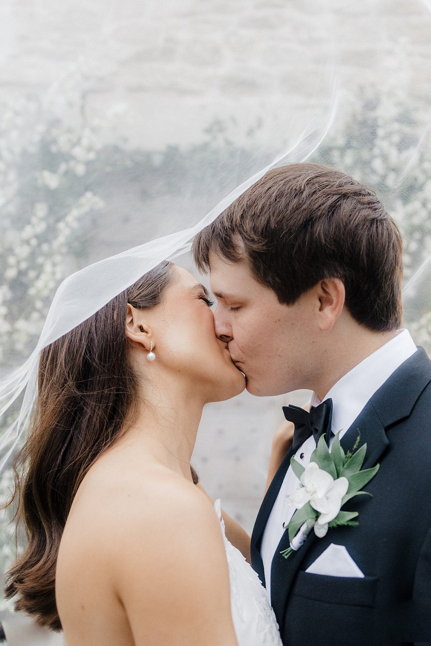 Bride & groom kissing under veil