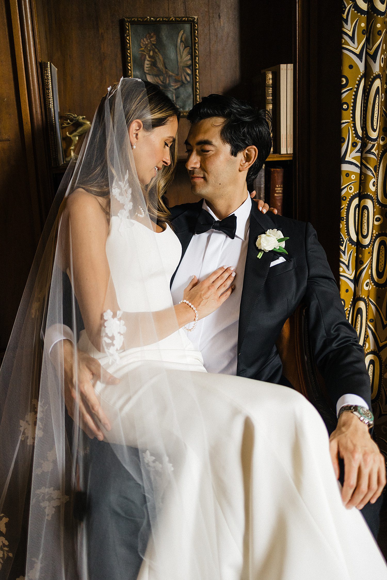 Bride sitting on groom's lap after ceremony