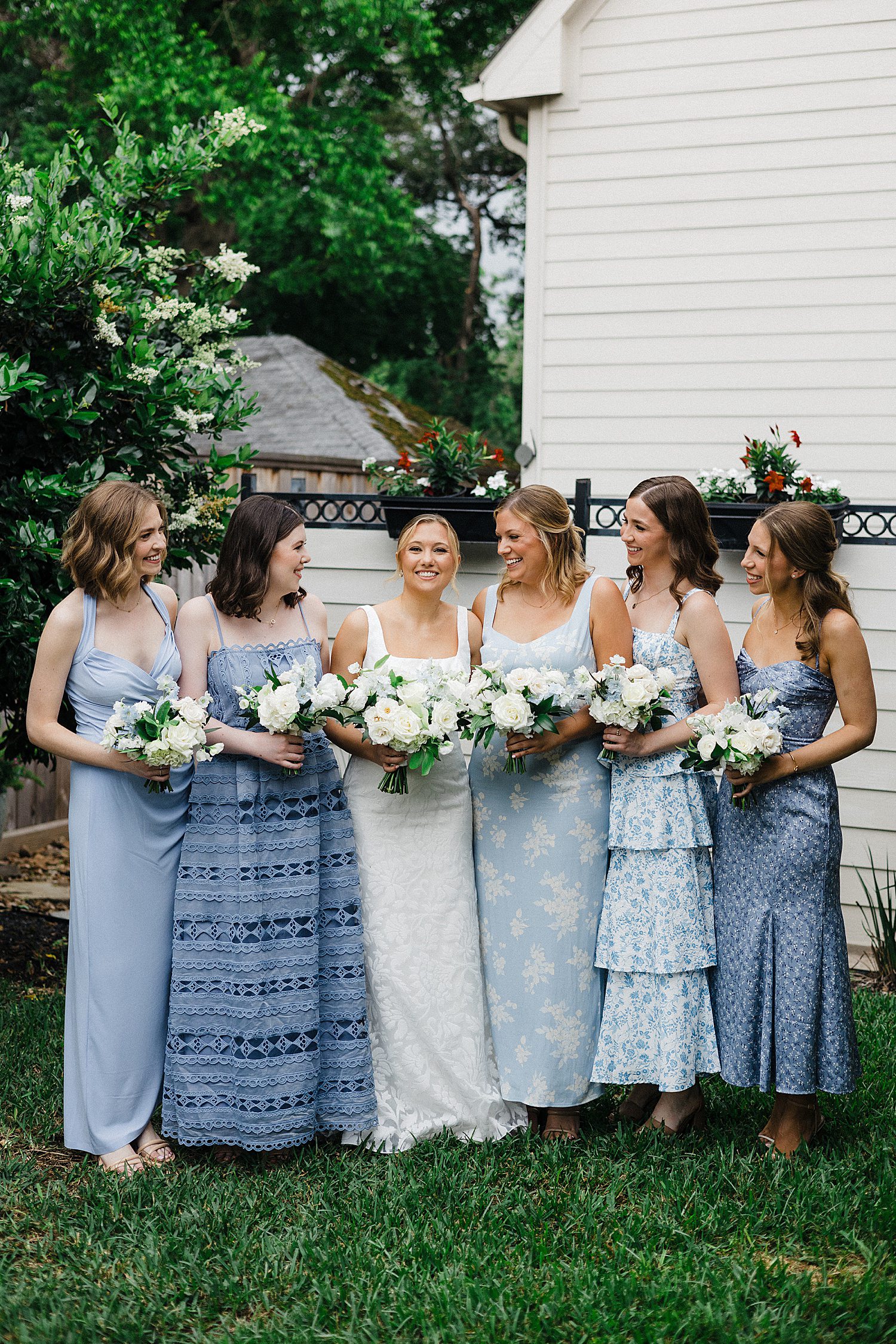 Bride in white and bridesmaids in shades of blue